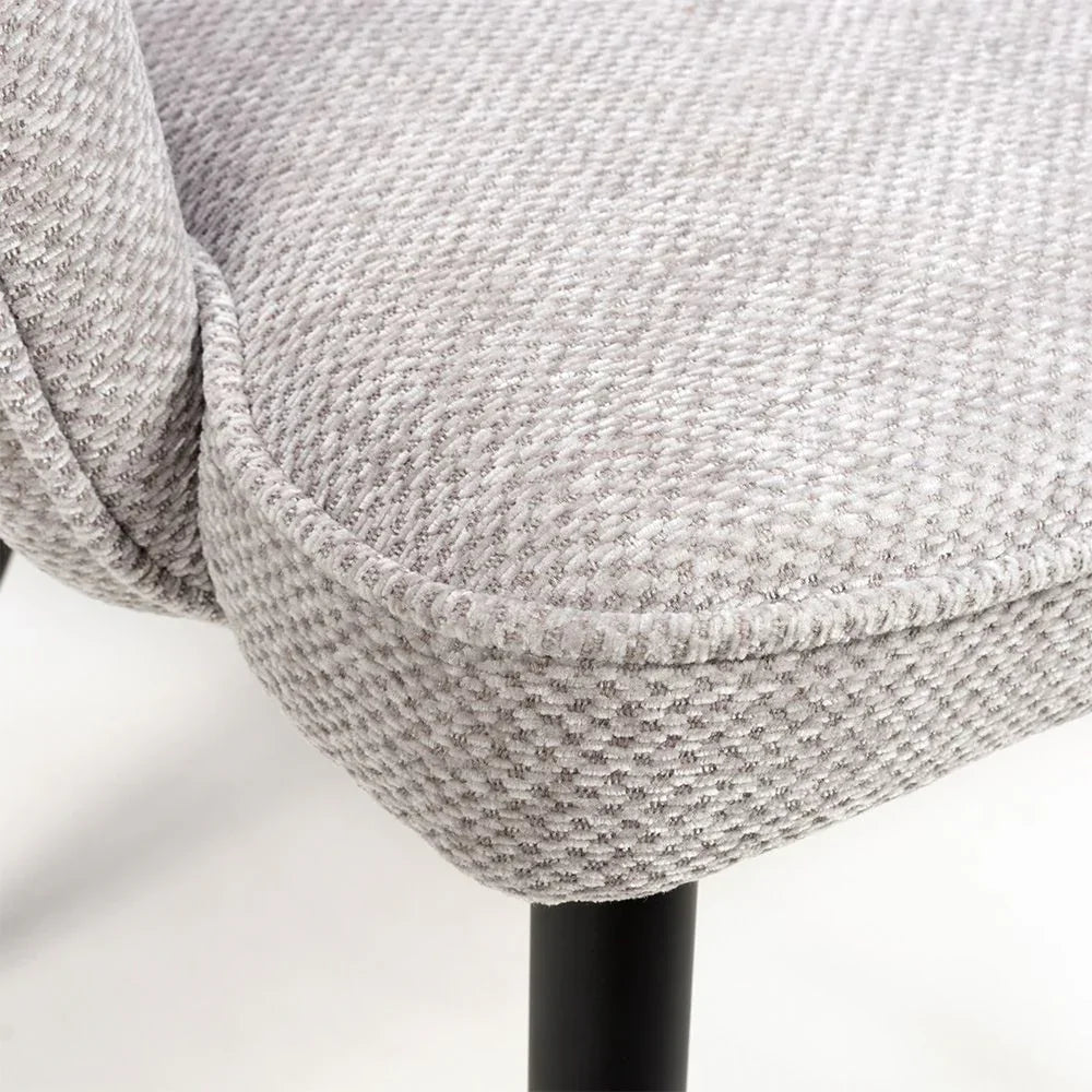 Light grey fabric dining chair seat with textured upholstery and black metal leg