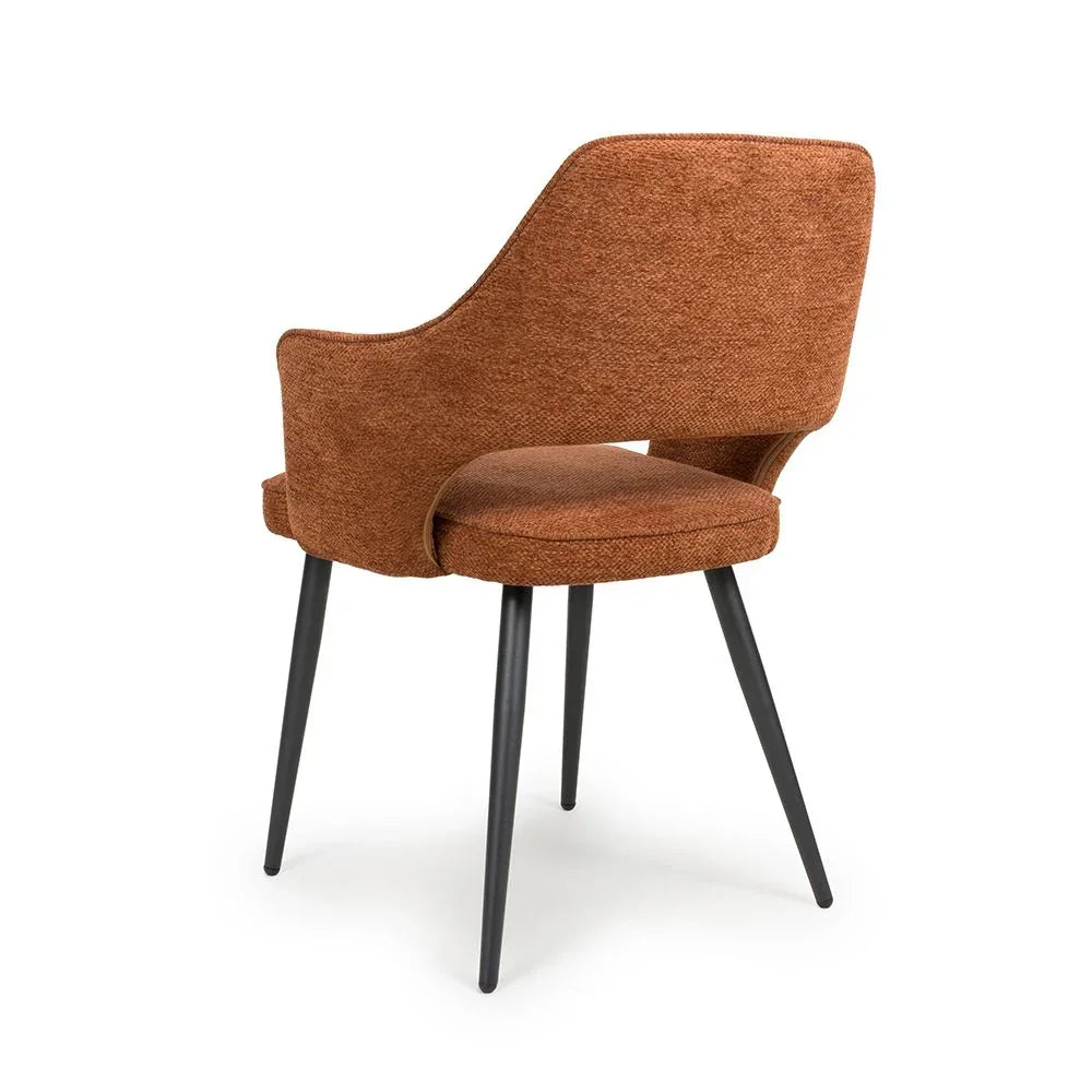 Brown fabric dining chair with curved backrest and black metal legs, rear angled view