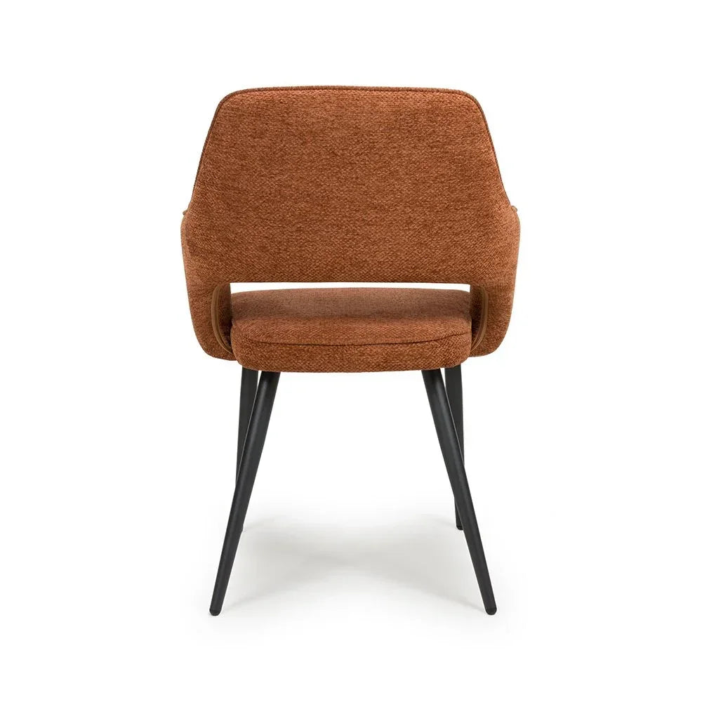 Rust fabric dining chair with curved backrest and black angled metal legs, rear view