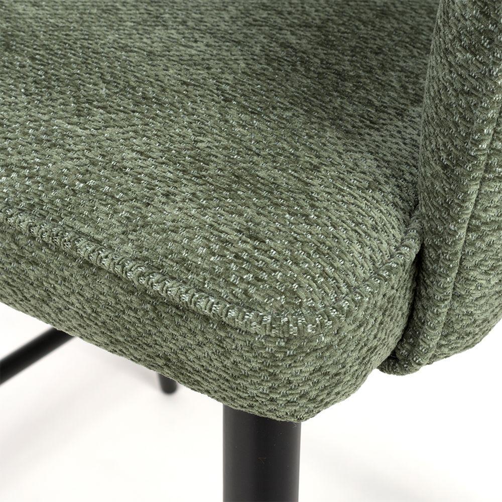 Close-up of green fabric dining chair seat with textured upholstery and black metal leg