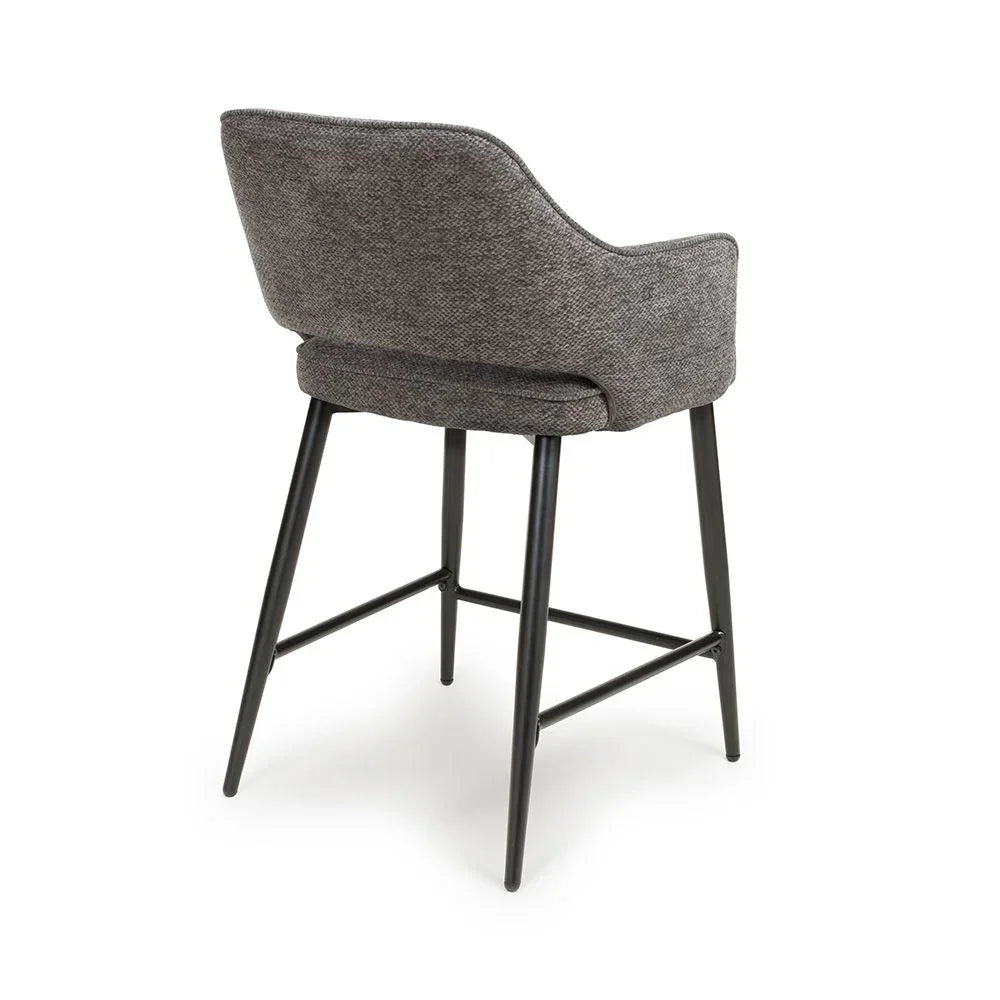 Grey bar stool with upholstered backrest and black metal legs, rear angle view