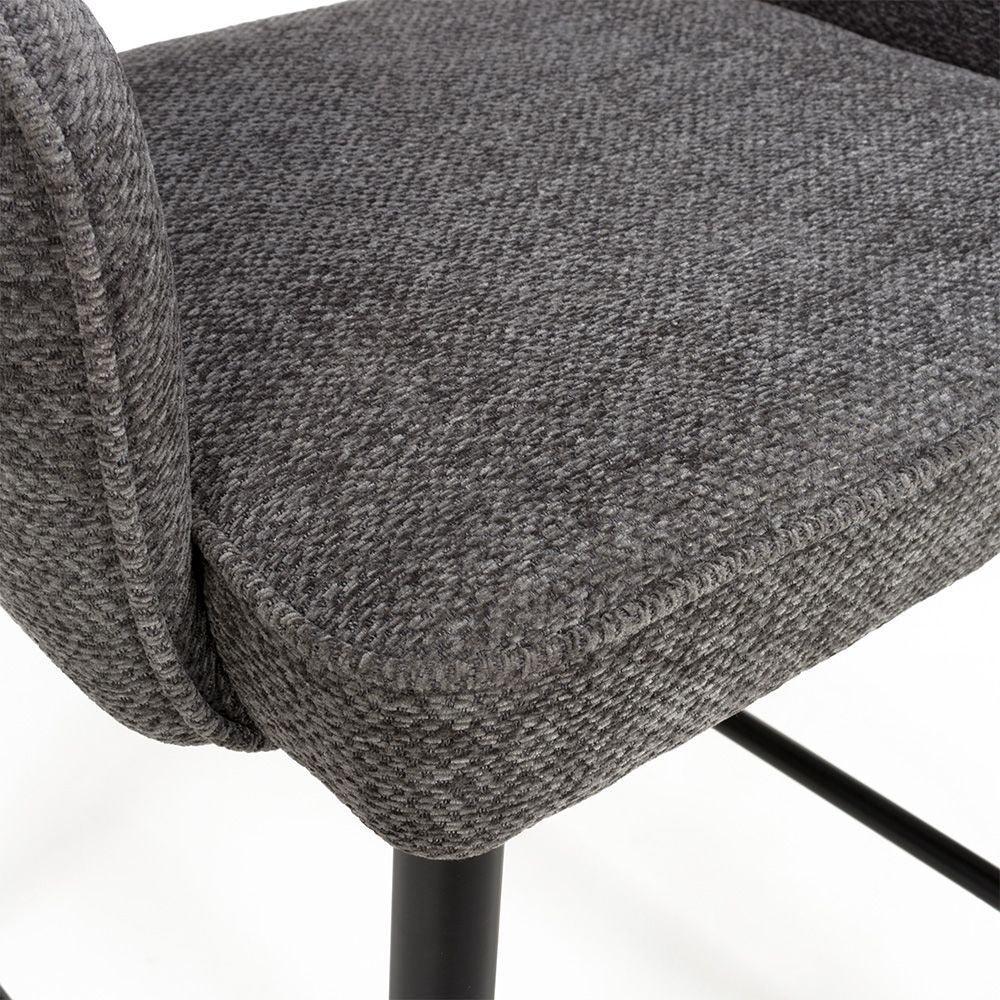 Closeup of grey fabric dining chair with black metal legs and textured upholstery