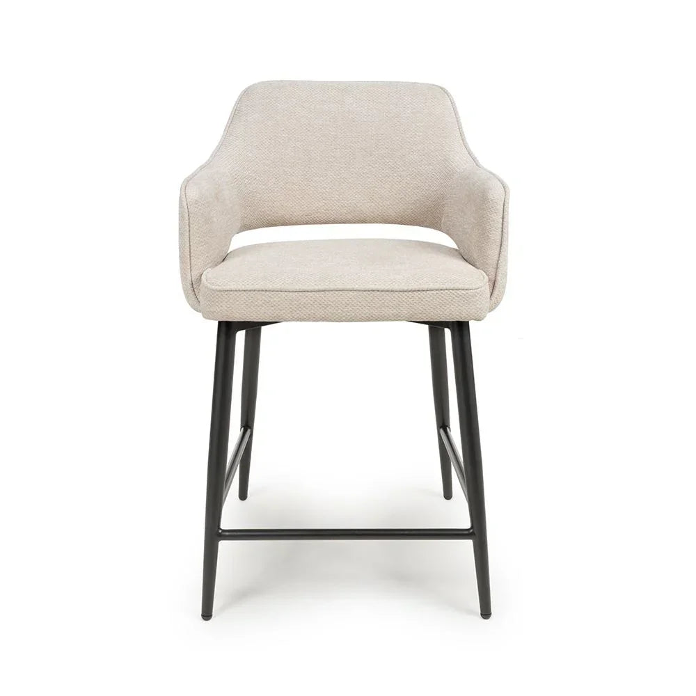 Beige upholstered bar stool with black metal legs, front view
