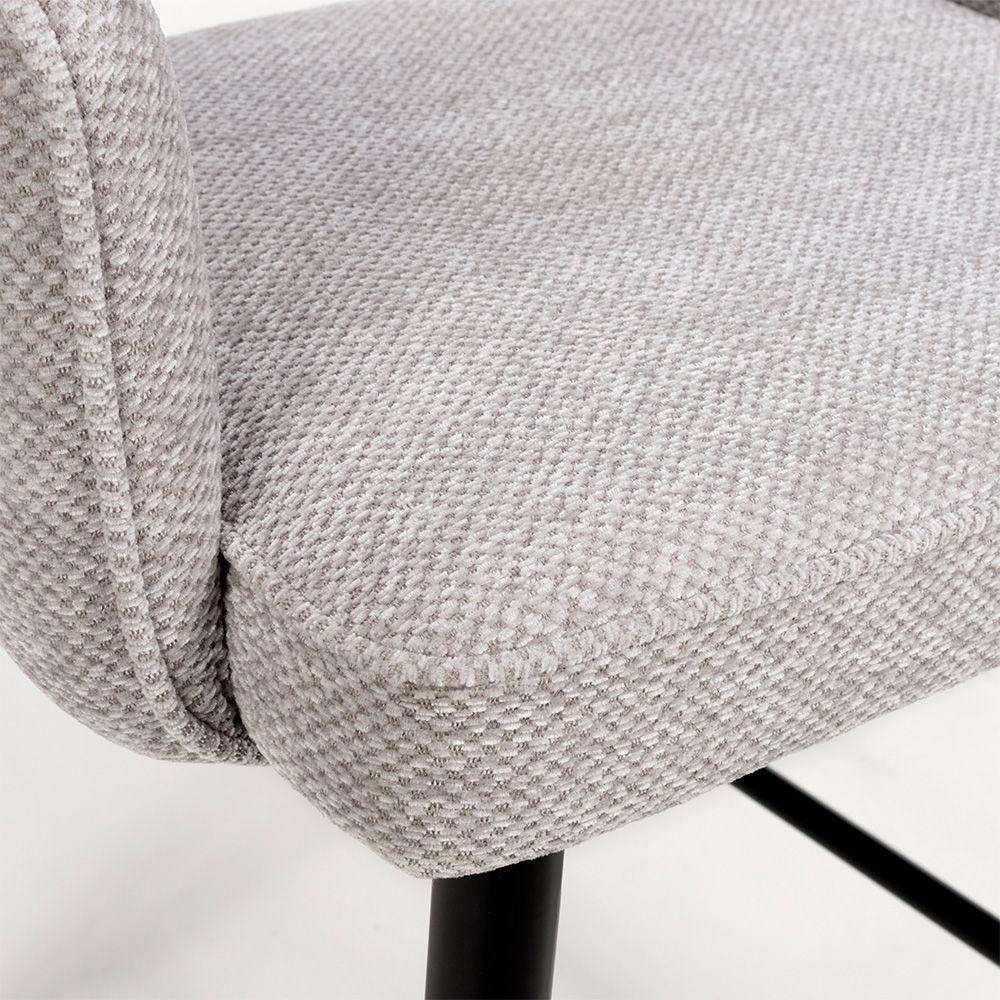 Close view of beige fabric dining chair seat with black metal legs
