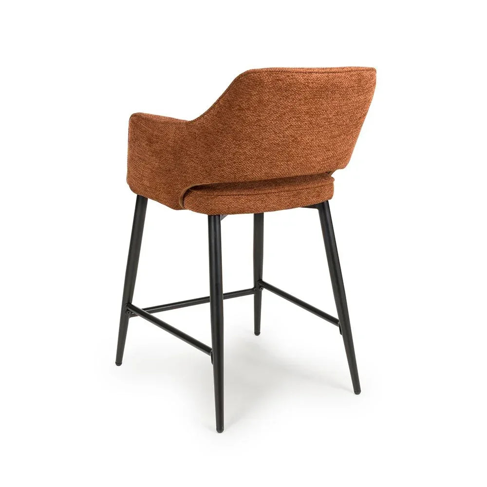 Rust fabric bar stool with black metal legs and curved backrest, rear angle view