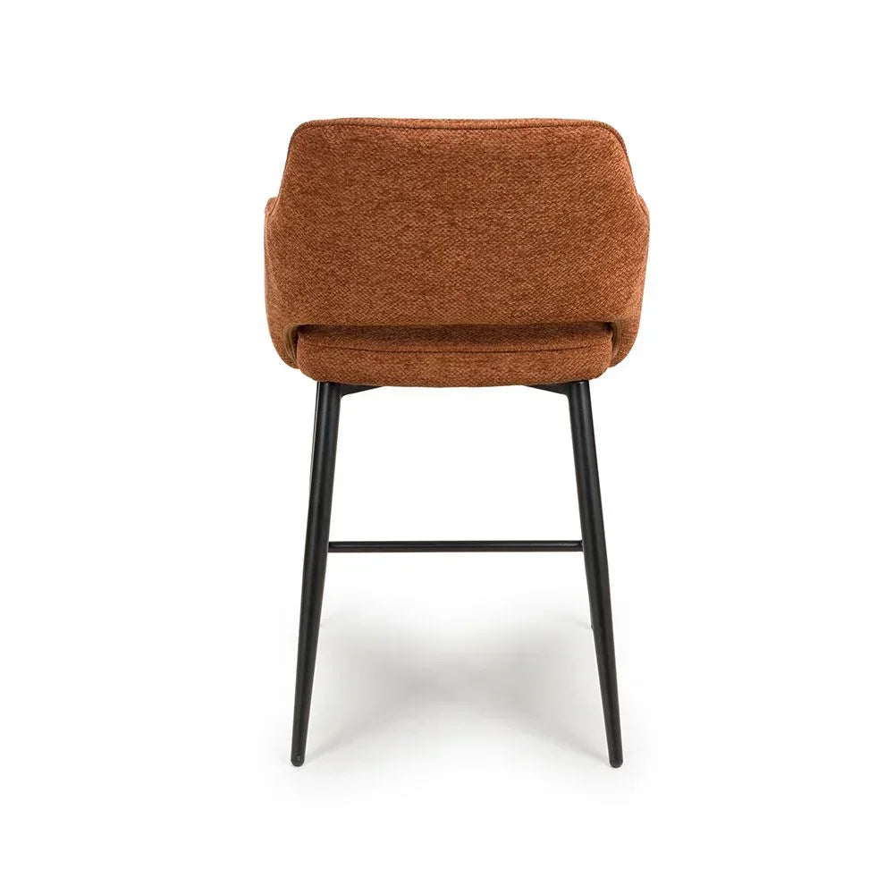 Rust fabric dining chair with black metal legs, rear view