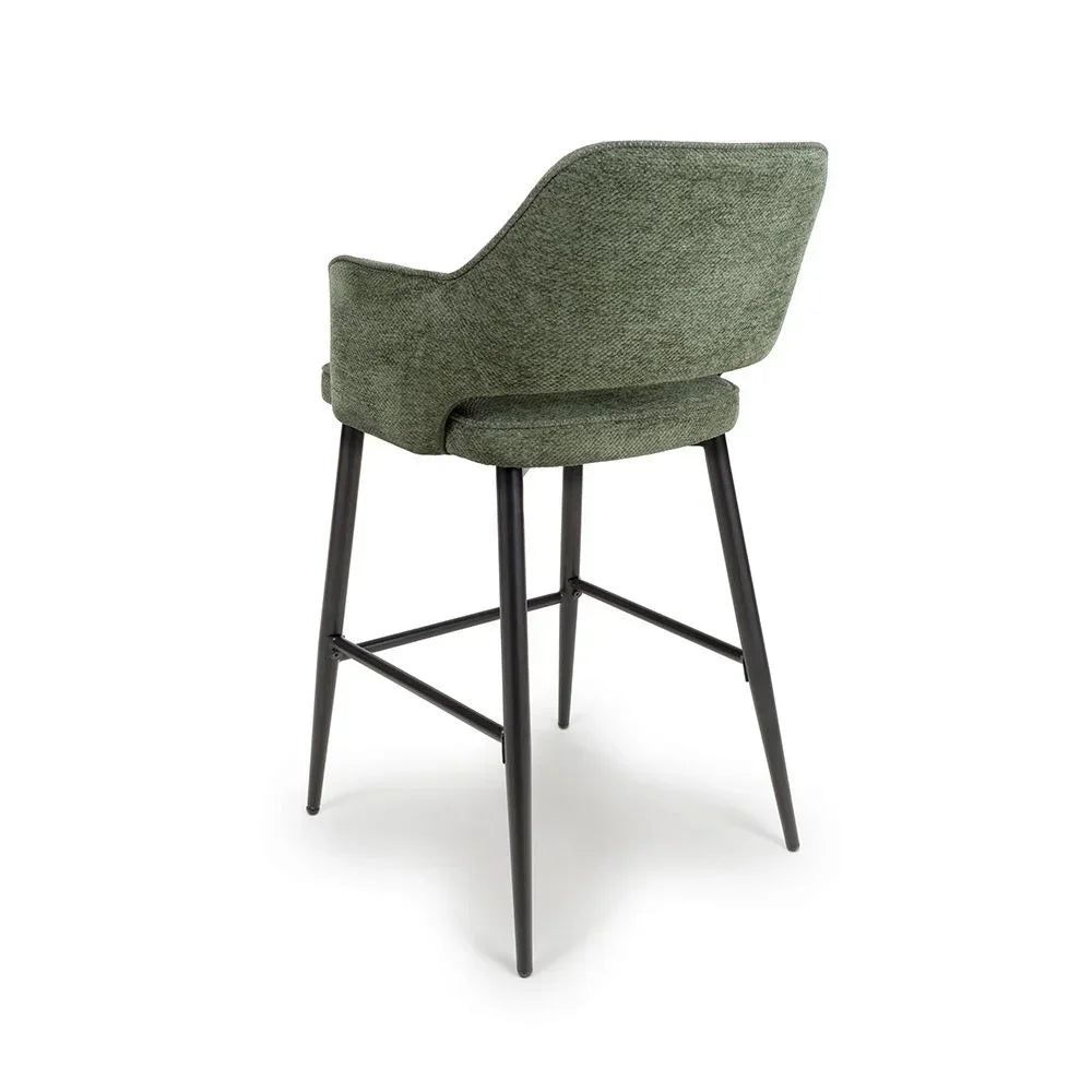 Green fabric bar stool with curved backrest and black metal legs, rear angle view