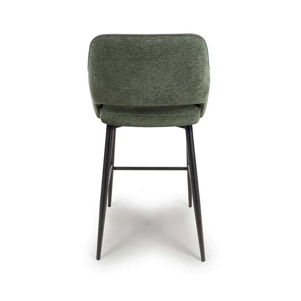 Green upholstered dining chair with black metal legs, rear view