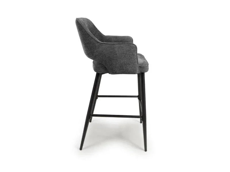 Grey fabric bar stool with curved backrest and black wooden legs, side profile view