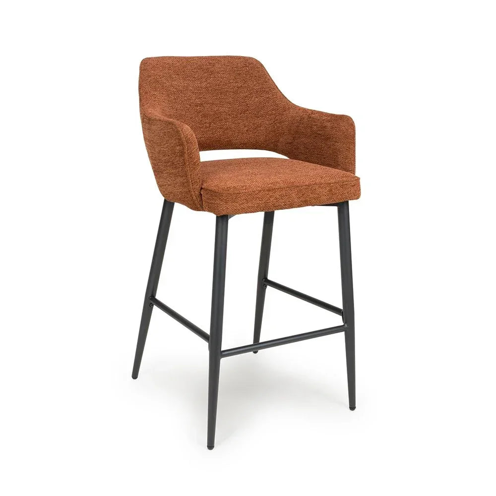 Rust fabric bar stool with armrests and black metal legs on white background