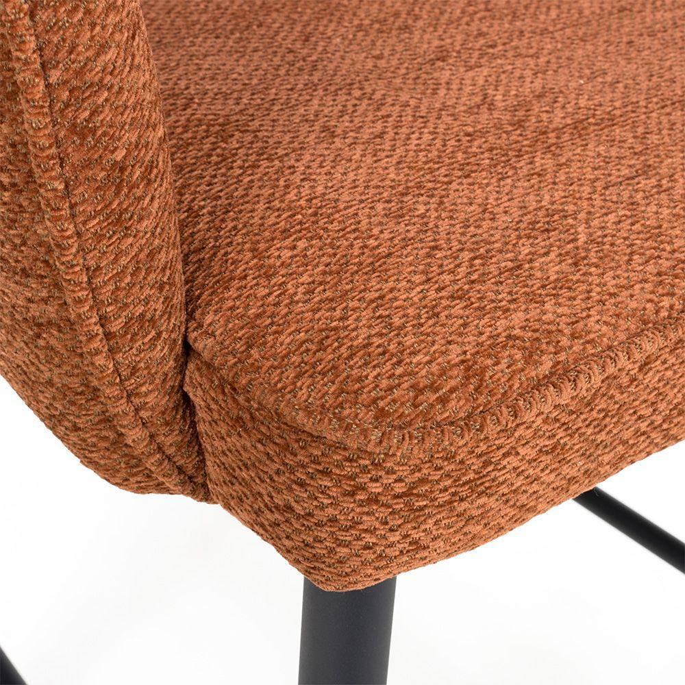 Textured rust fabric dining chair with black metal legs, close-up of seat and side