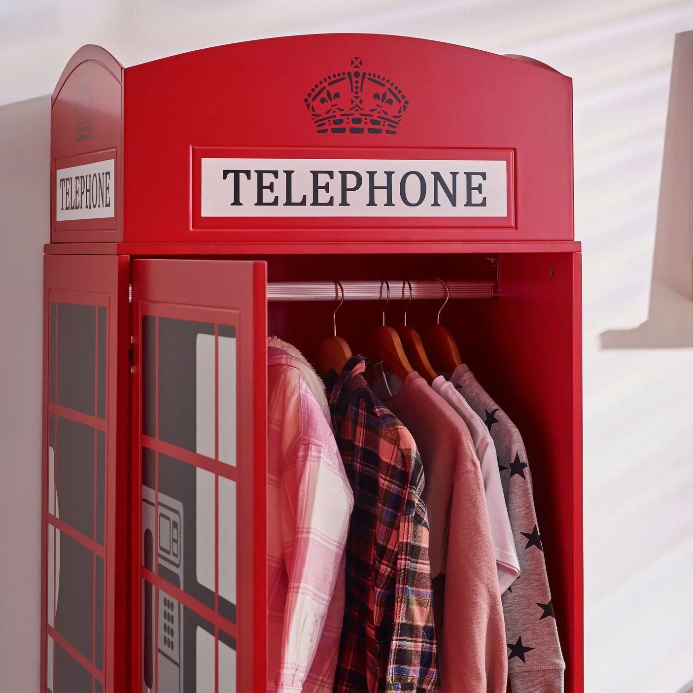 Red telephone box wardrobe with hanging clothes inside, detailed door view