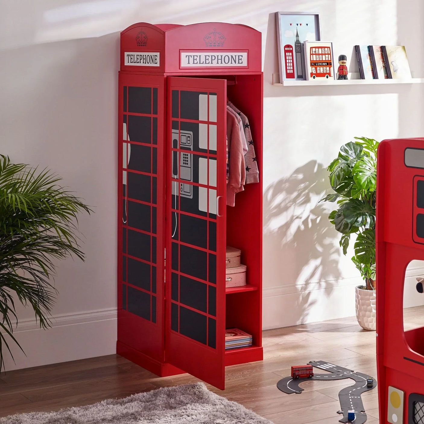 Red telephone box wardrobe with shelves and hanging rail in a modern children’s bedroom