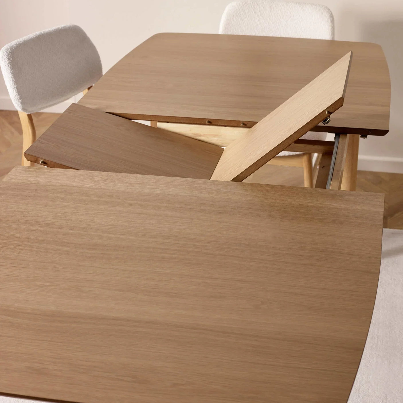 Oak dining table with butterfly leaf extension, close view of mechanism and two fabric chairs