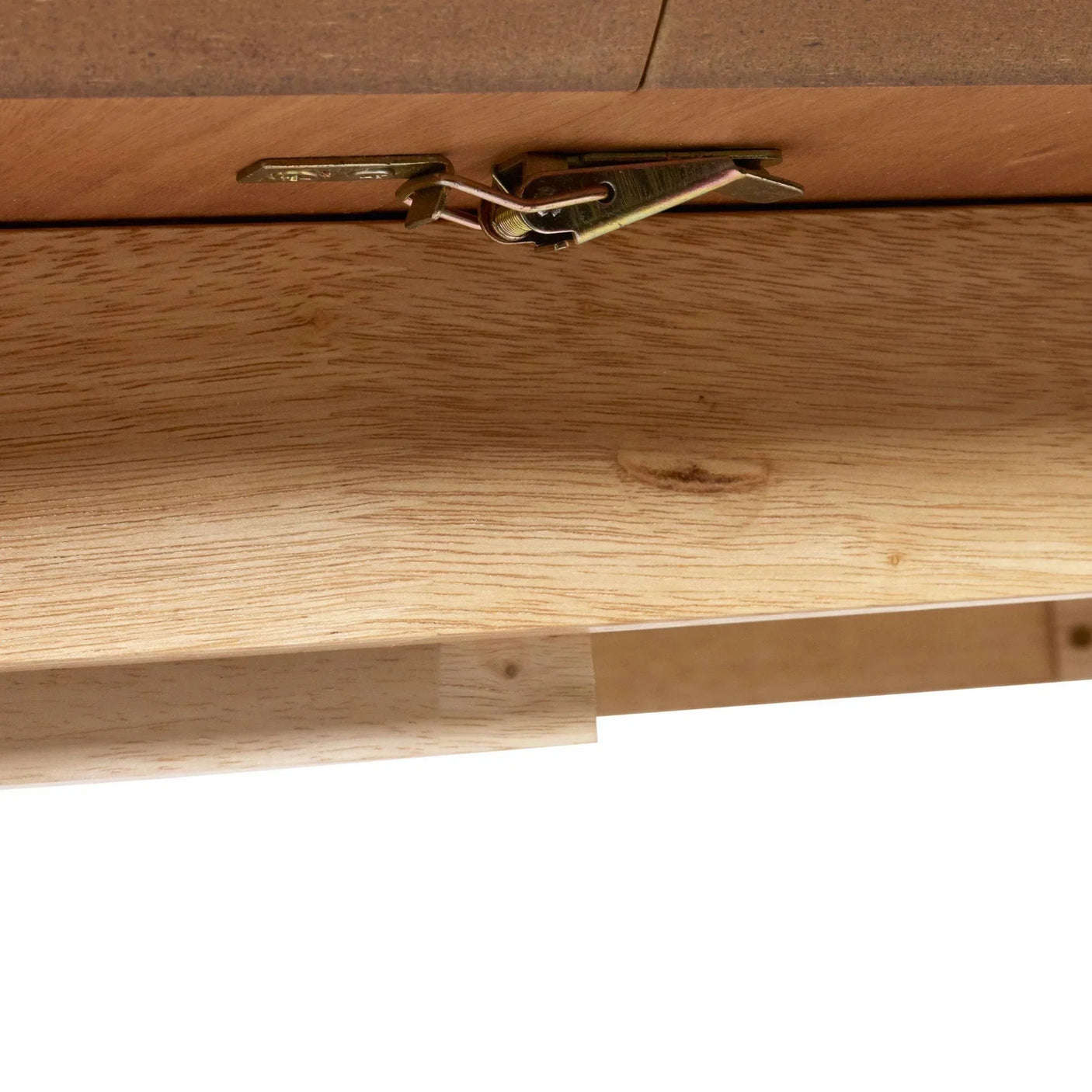 Closeup of metal latch on light wood dining table underside