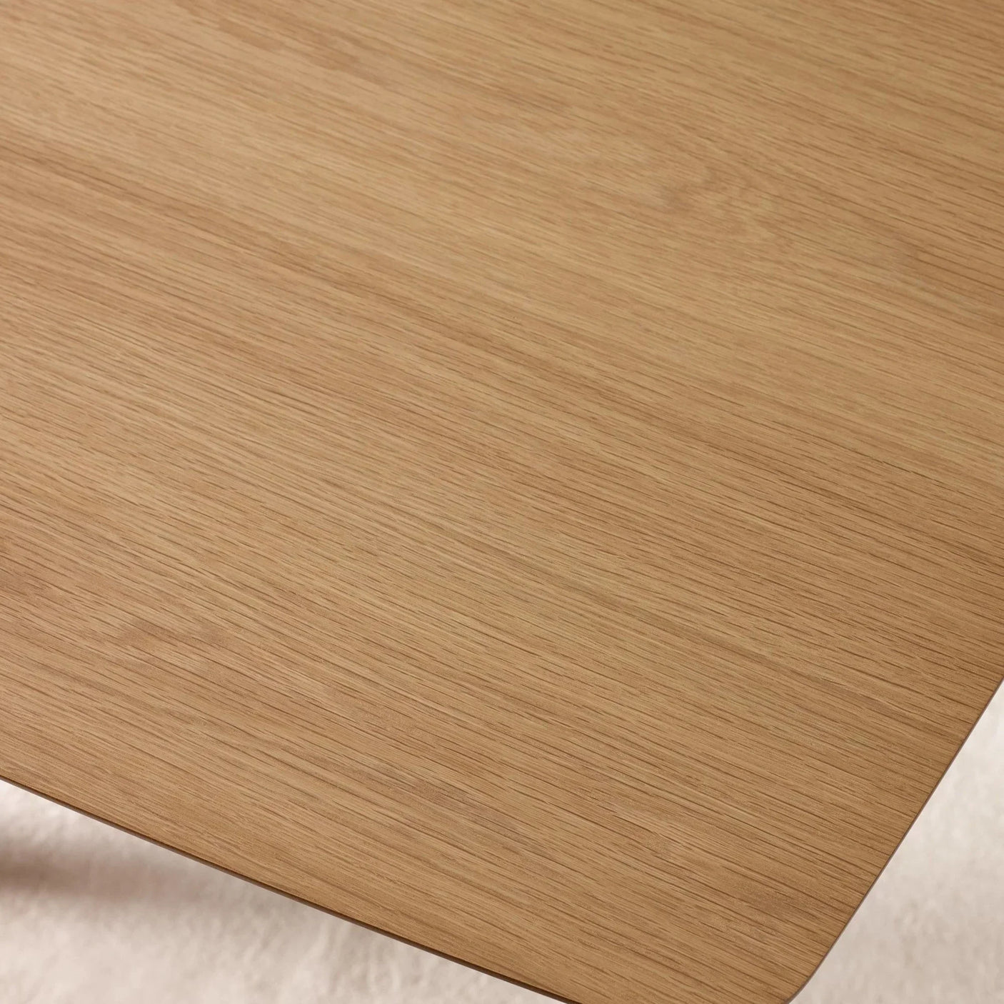 Close view of light oak dining table top with smooth wood grain texture