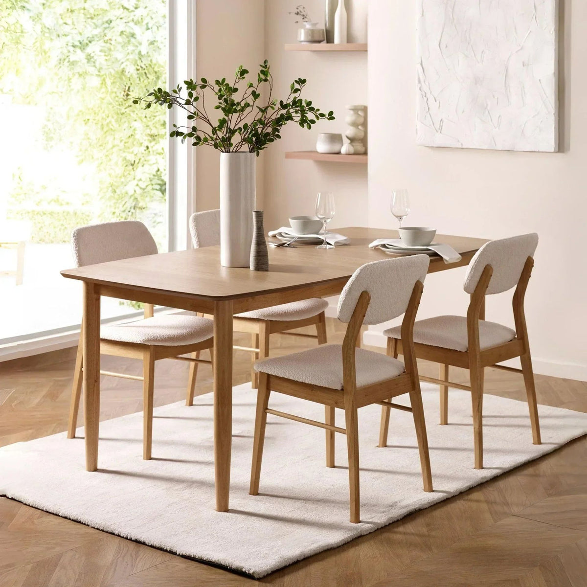 Oak dining table with cream boucle chairs in a bright room