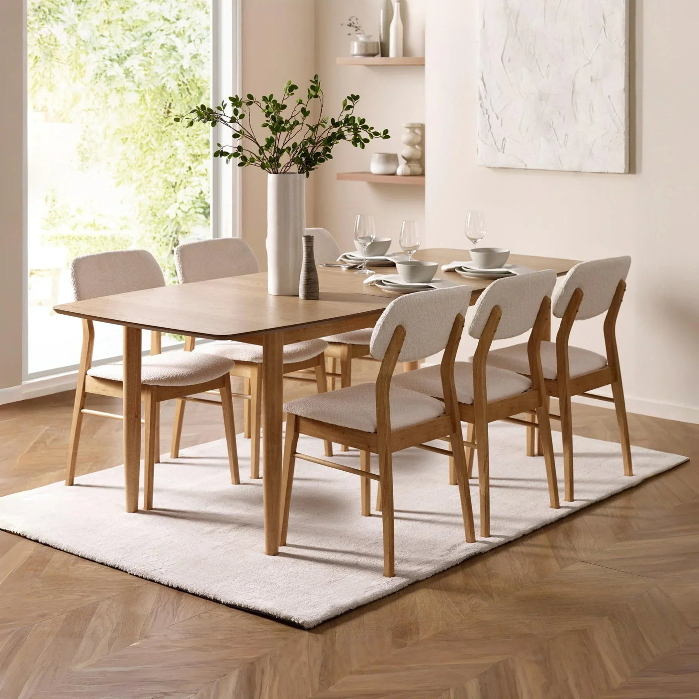Oak dining table set with six cream upholstered chairs on white rug in modern dining room