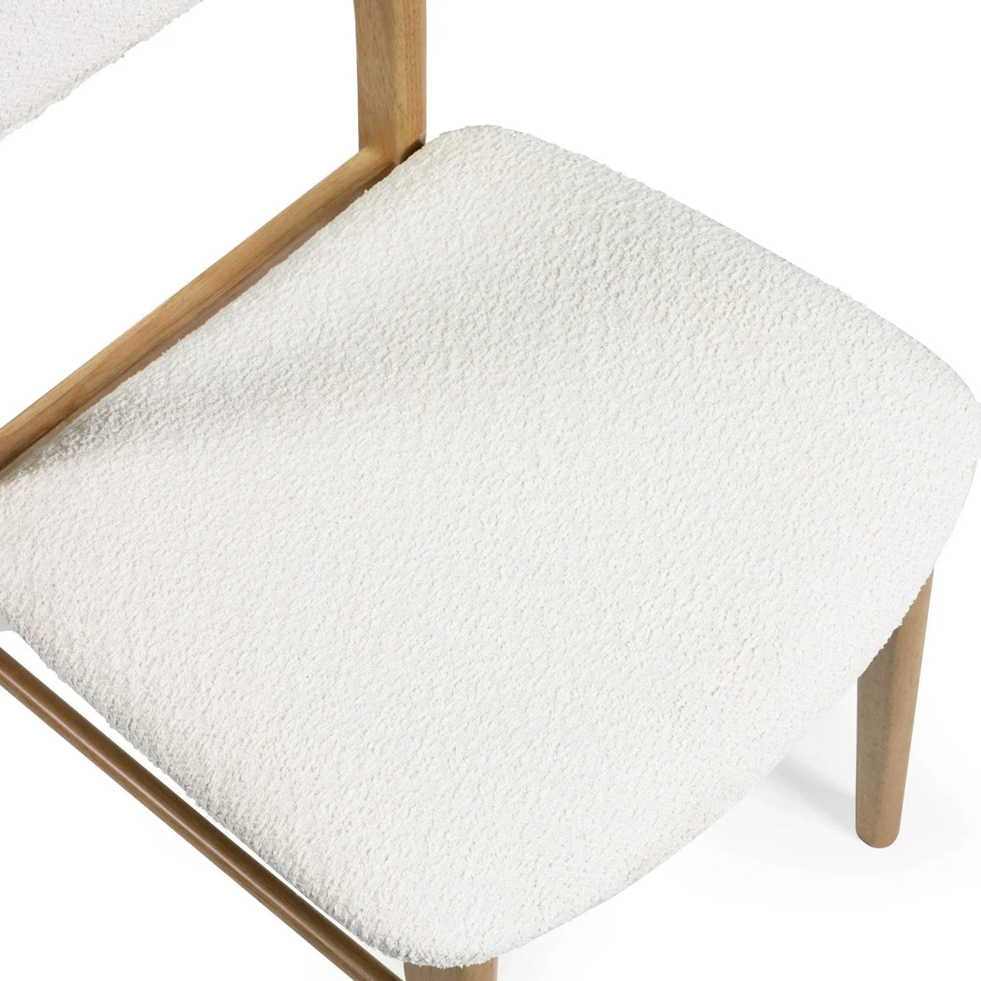 Closeup of boucle dining chair with wooden legs and textured white seat upholstery