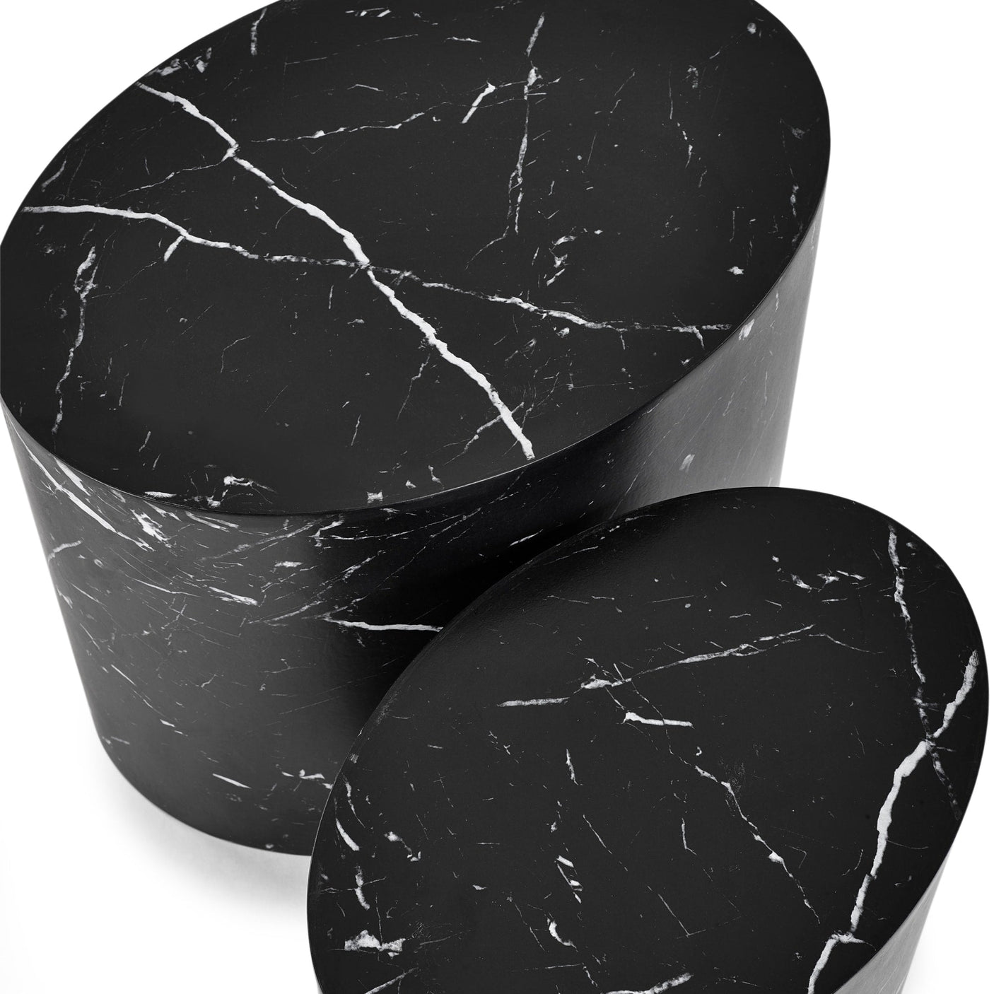 Close-up top view of two black oval nest tables with white marble veining on white background