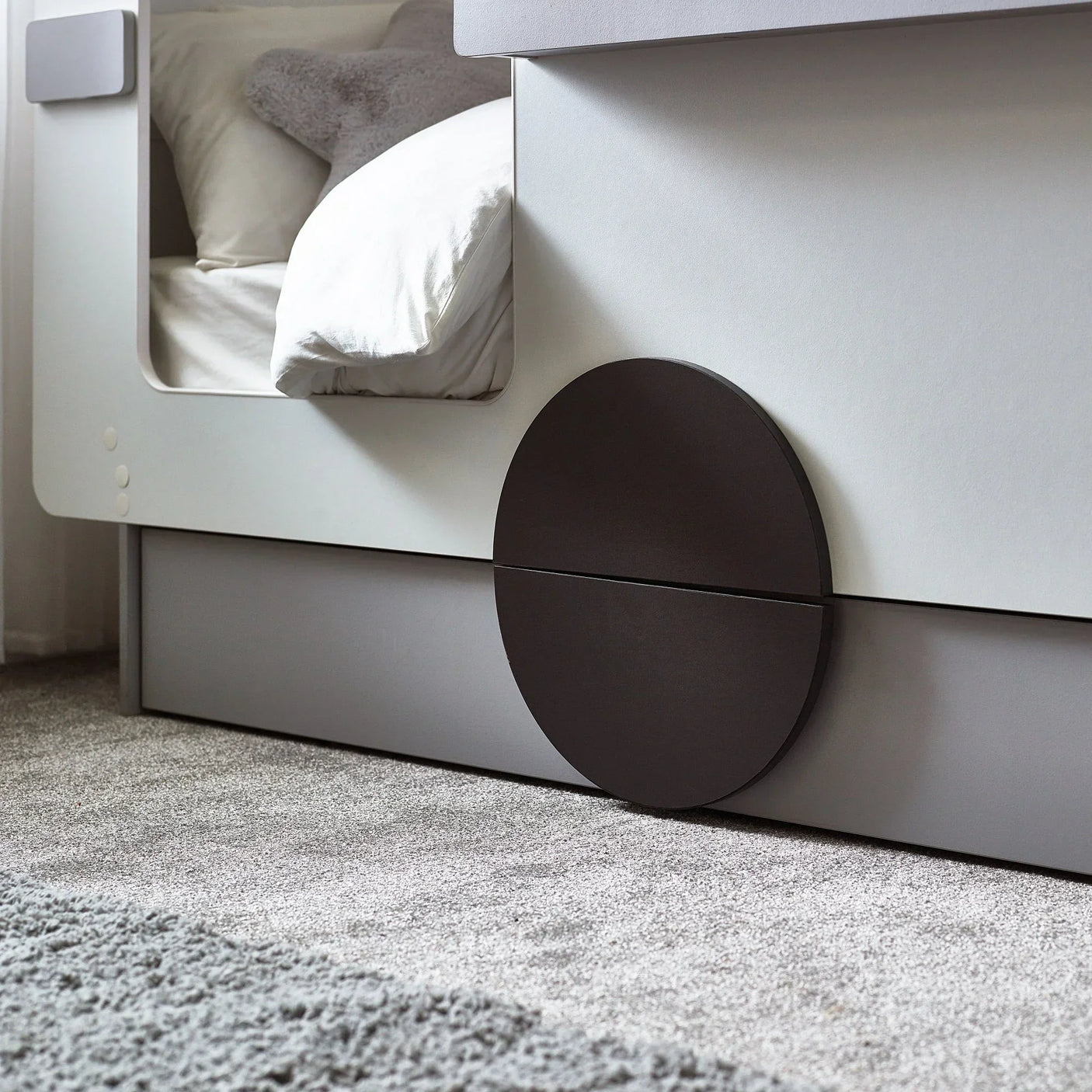 Tourer caravan bed with grey frame, storage drawer and round black detail on carpet