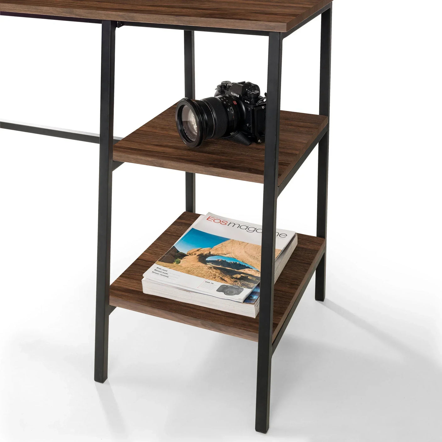 Walnut desk with black metal frame, two open shelves holding a camera and stacked magazines