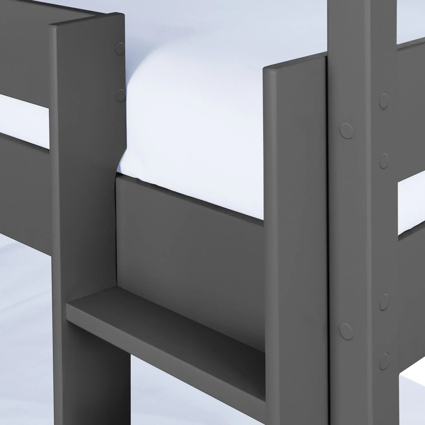 Grey wooden bunk bed frame closeup with white mattress and side safety guard