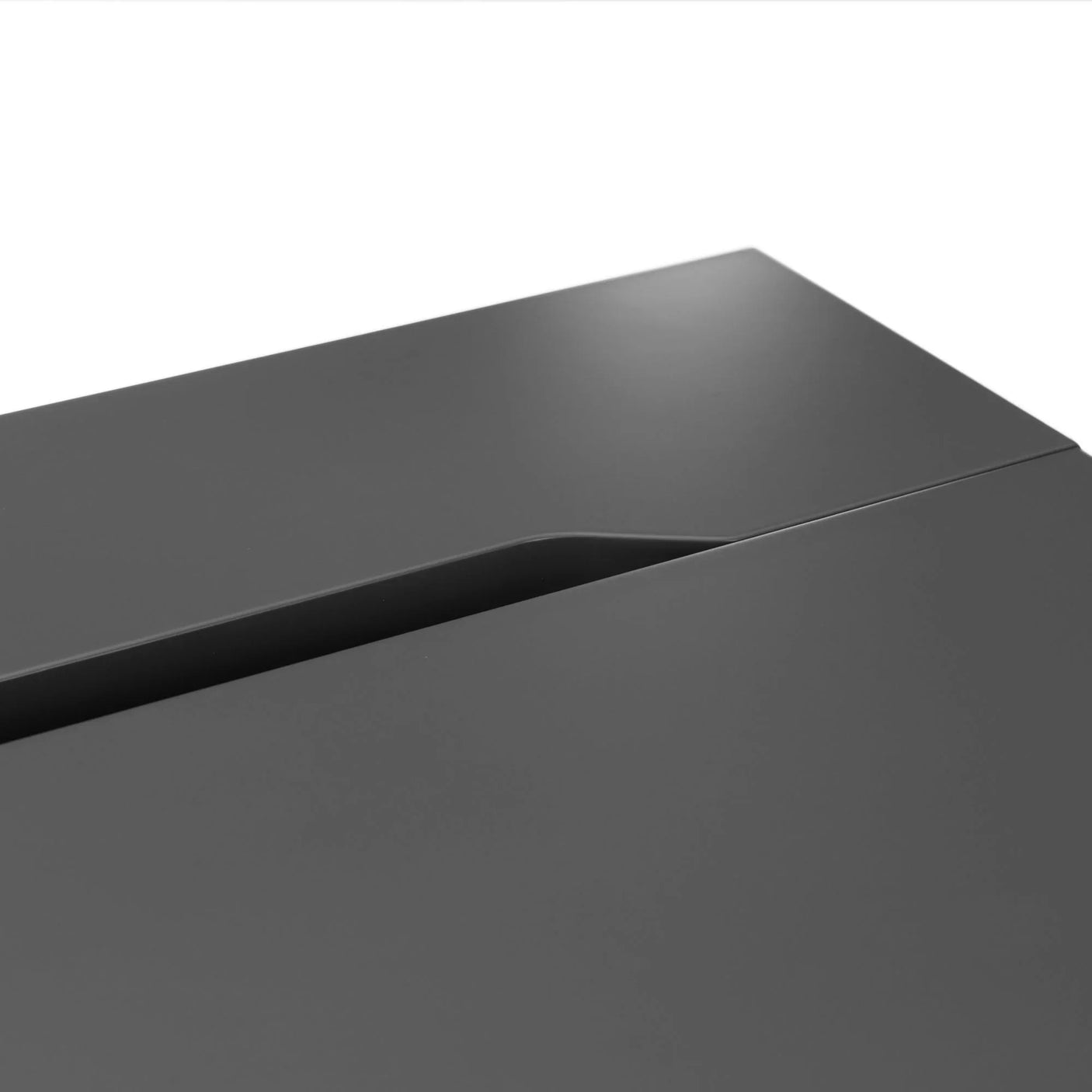 Closeup of modern grey desk surface with integrated cable management slot