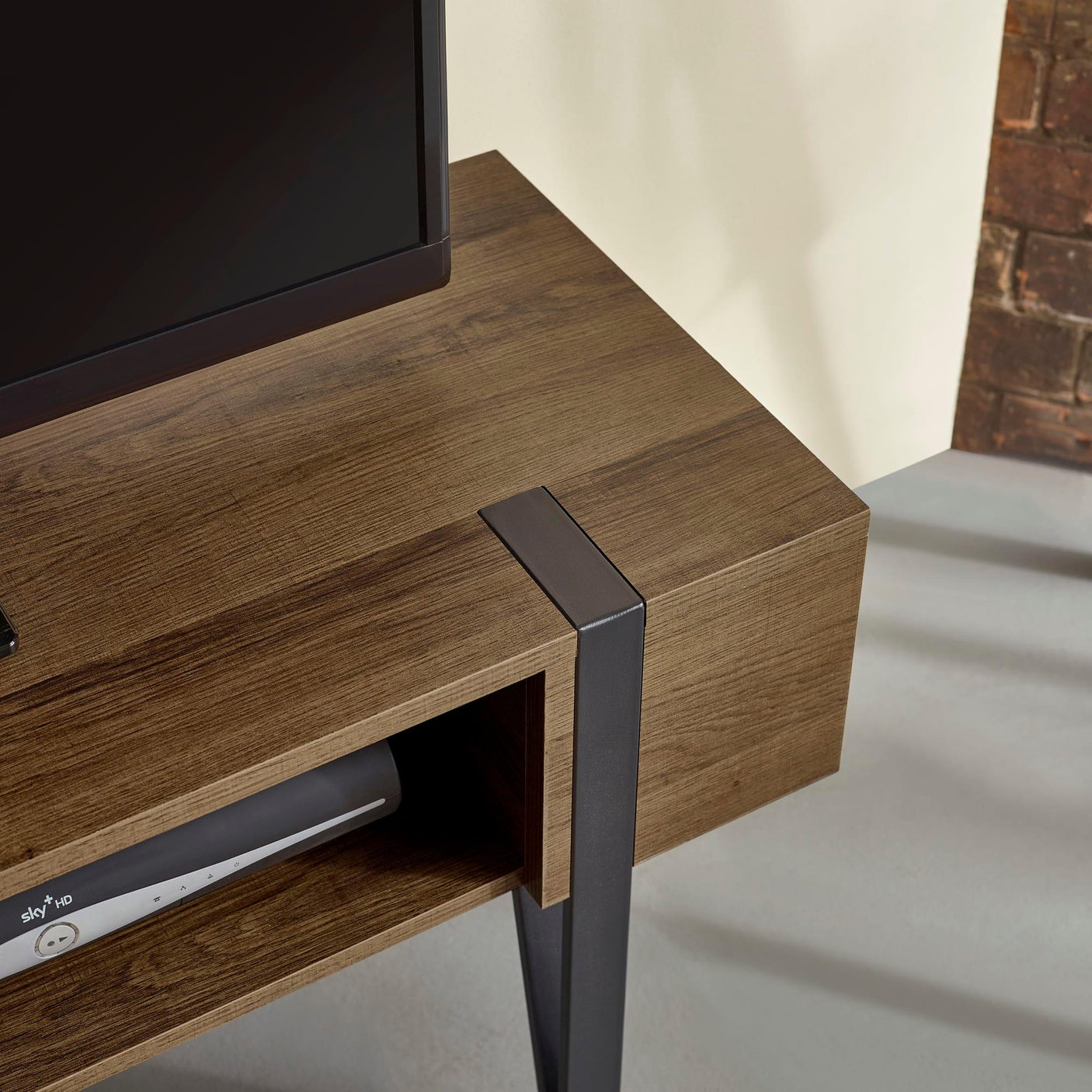 Wooden TV unit with metal legs and open shelf, close-up of corner and material detail