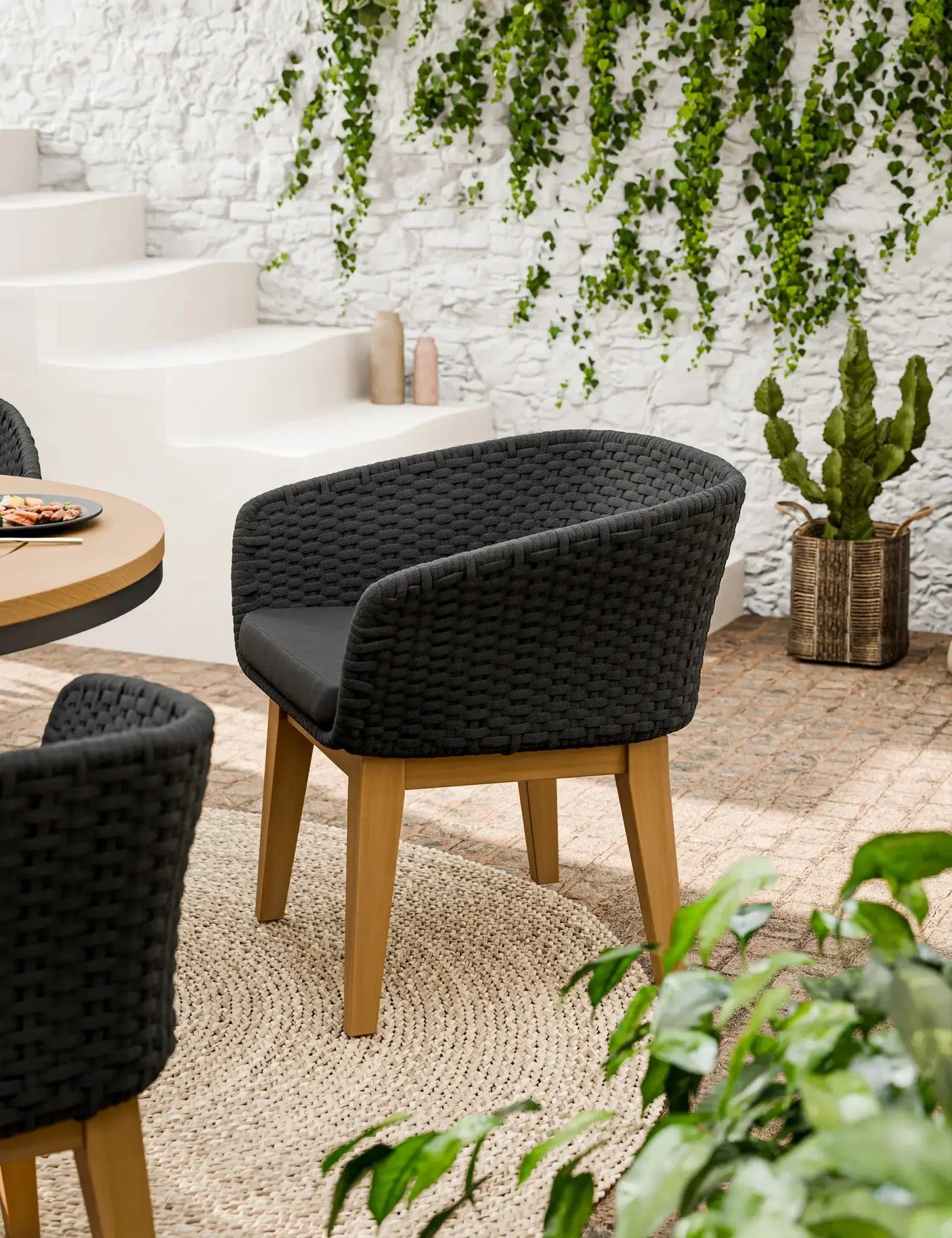 Black woven dining chair with wooden legs on beige rug in modern indoor setting