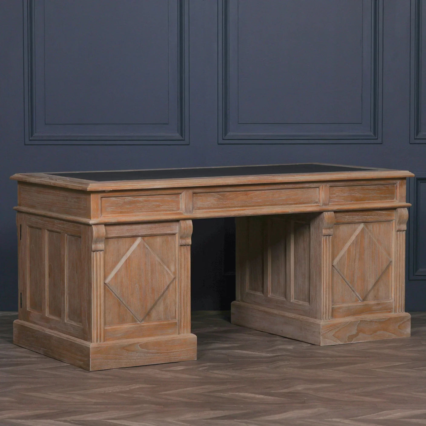 Rustic wooden office desk with panel detailing and black top on herringbone floor