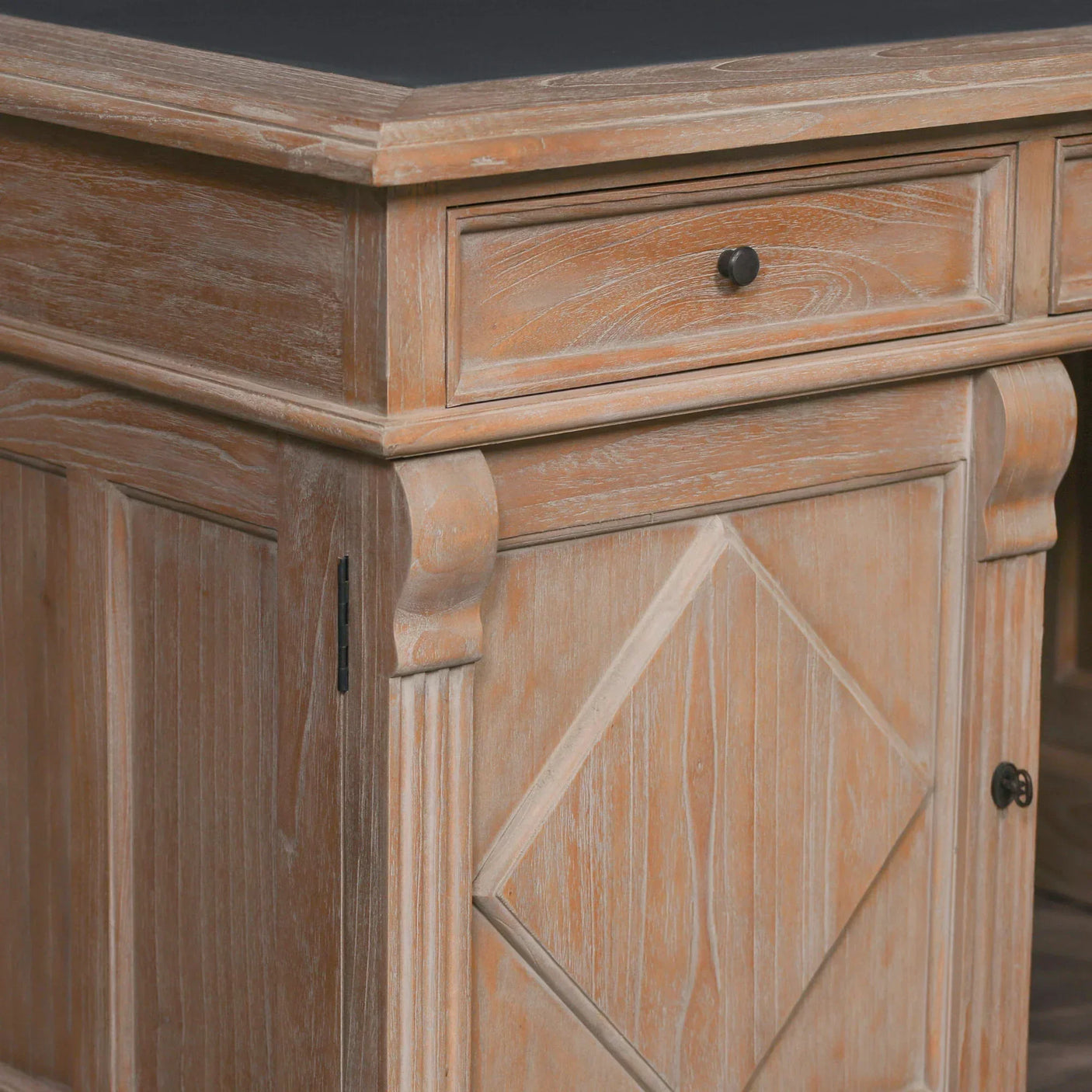 Corner of wooden sideboard with carved detail and drawer, natural finish, rustic style