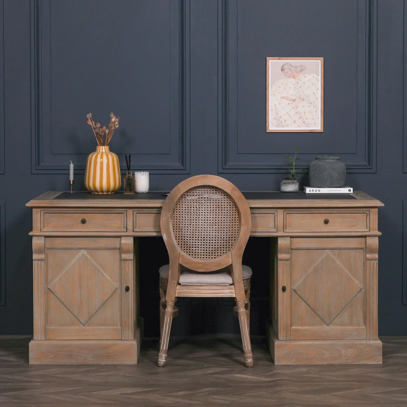Rustic wood writing desk with cane back chair and decorative accessories in home office