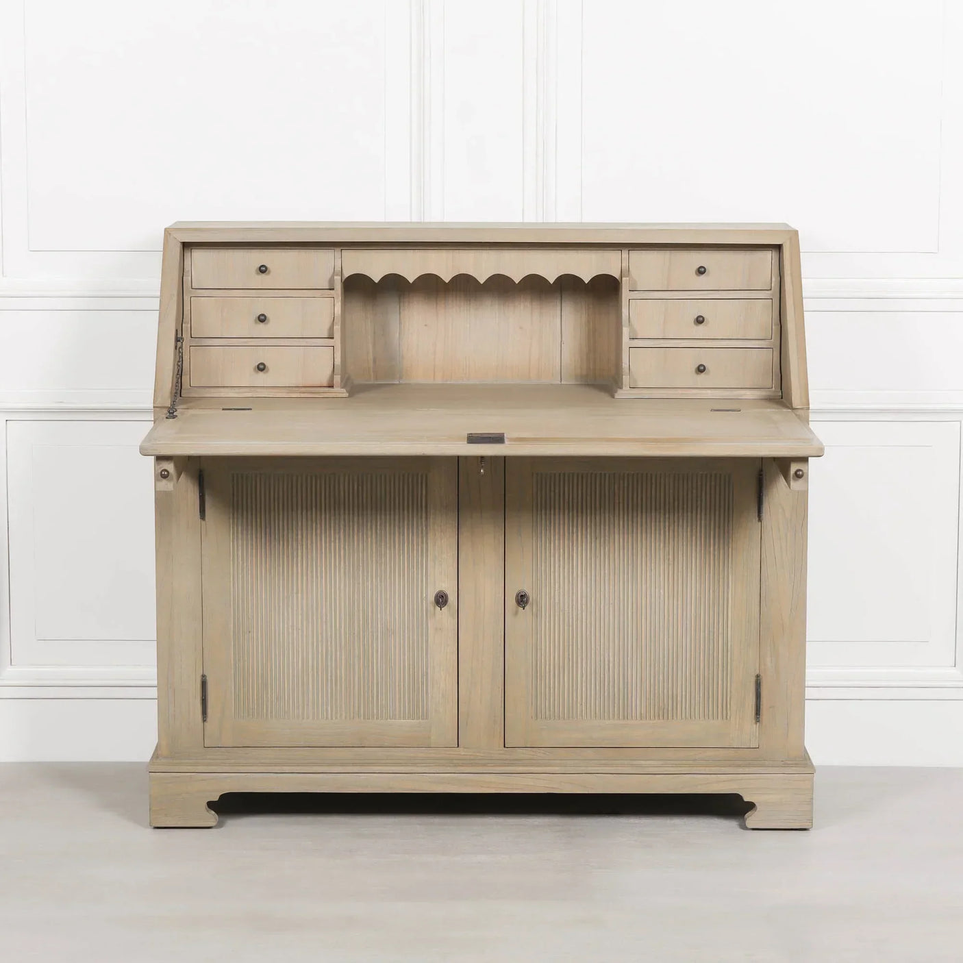Light wood writing desk with fold-down top, small drawers, and two-door cabinet base