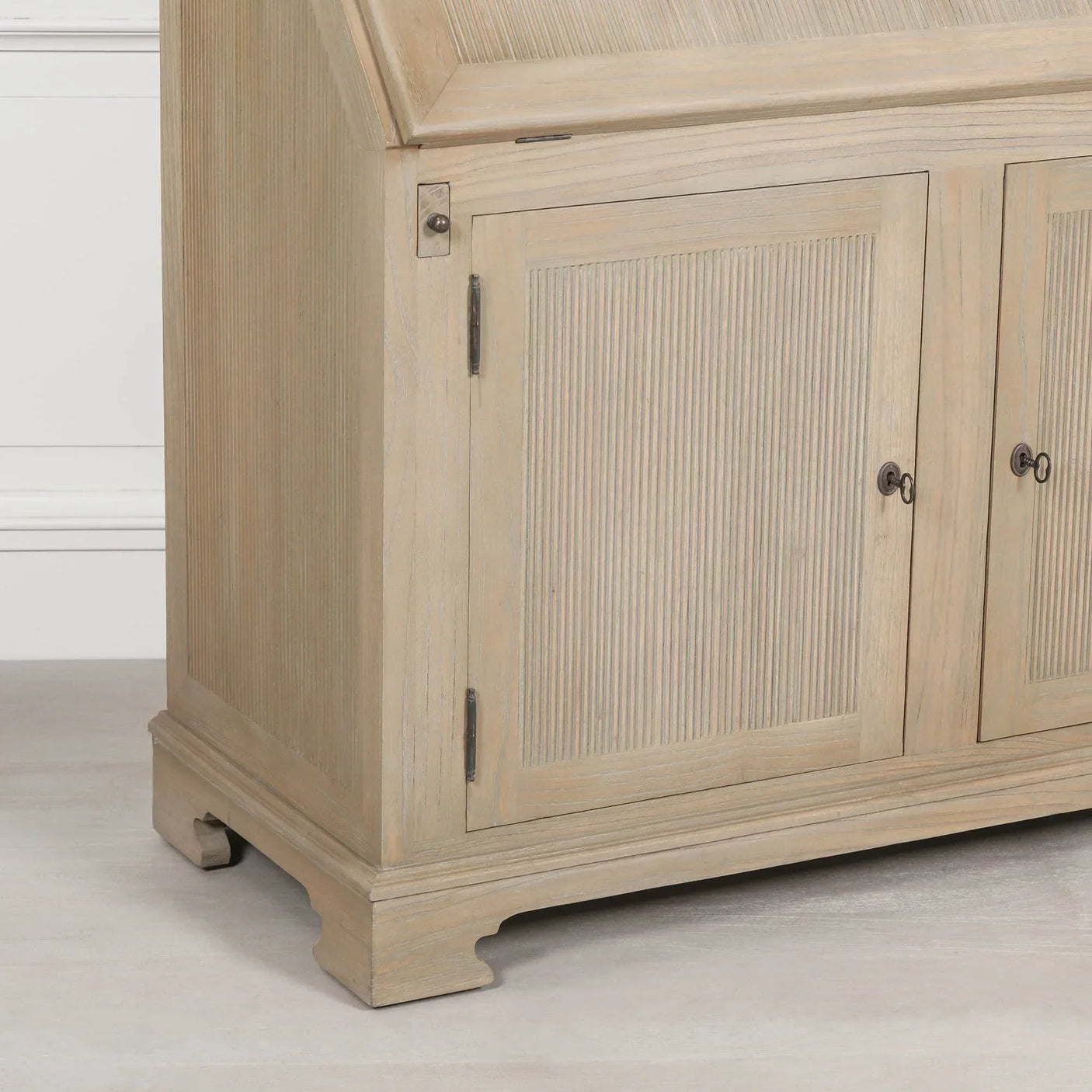 Light oak wooden sideboard with grooved cabinet doors and classic plinth base