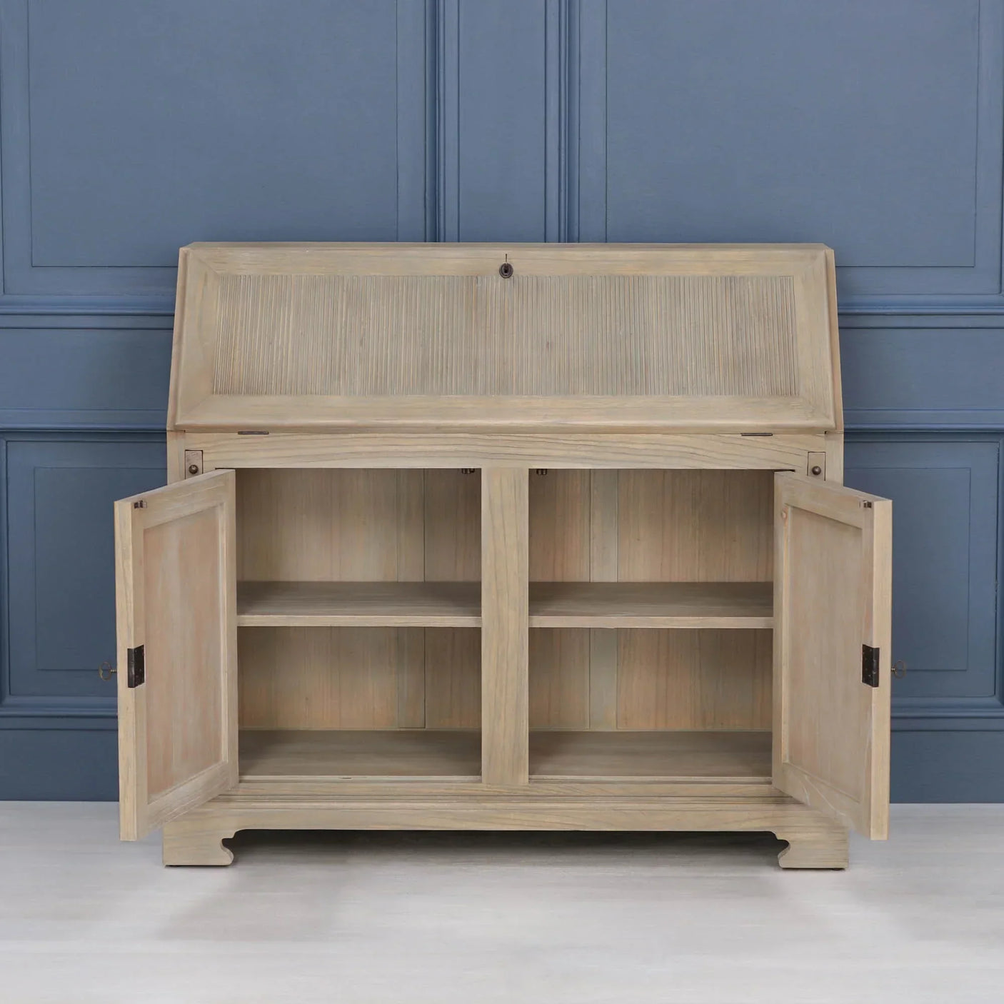 Natural wood sideboard cabinet with open doors and interior shelves against blue wall