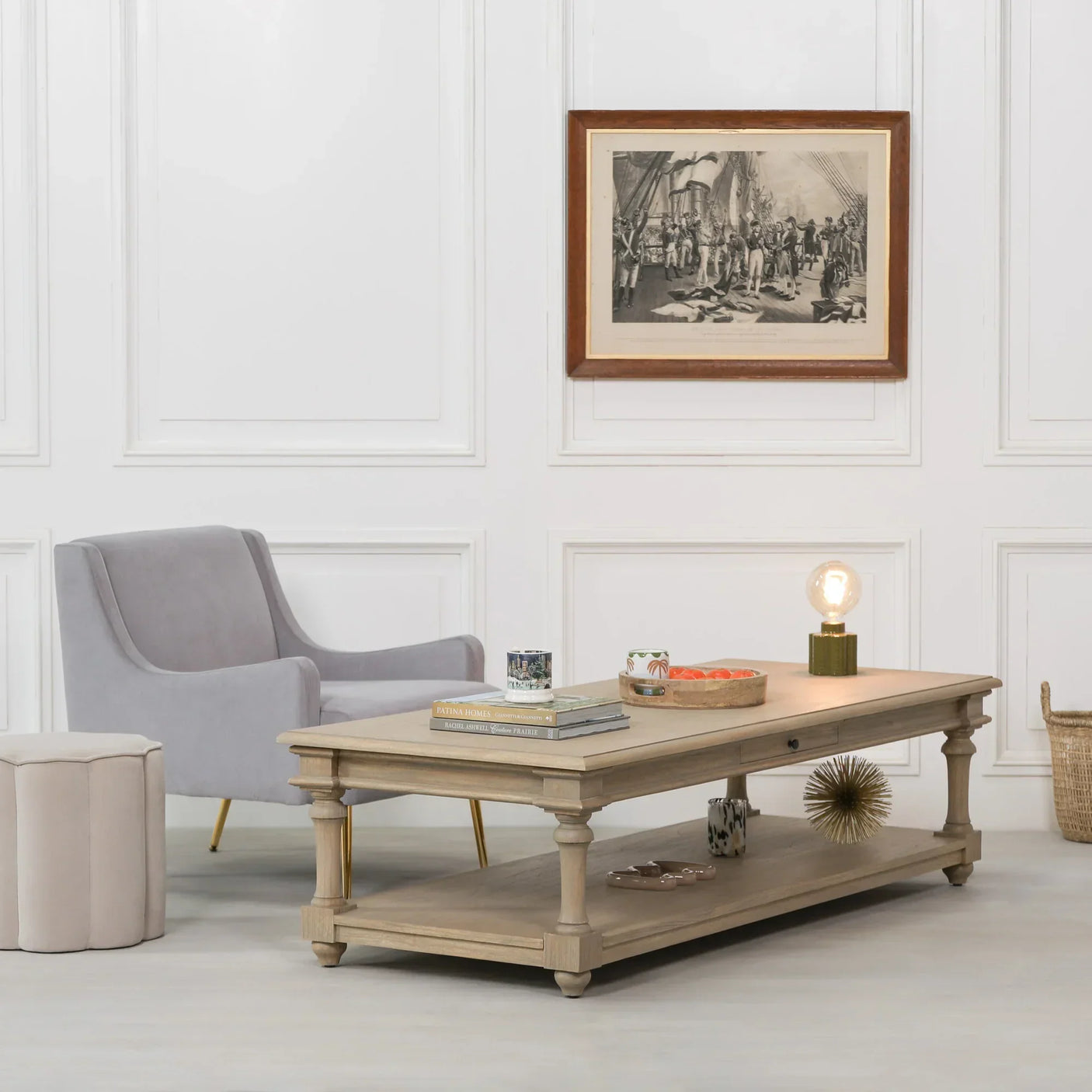 Light wood coffee table with shelf in modern living room with grey armchair and wall art