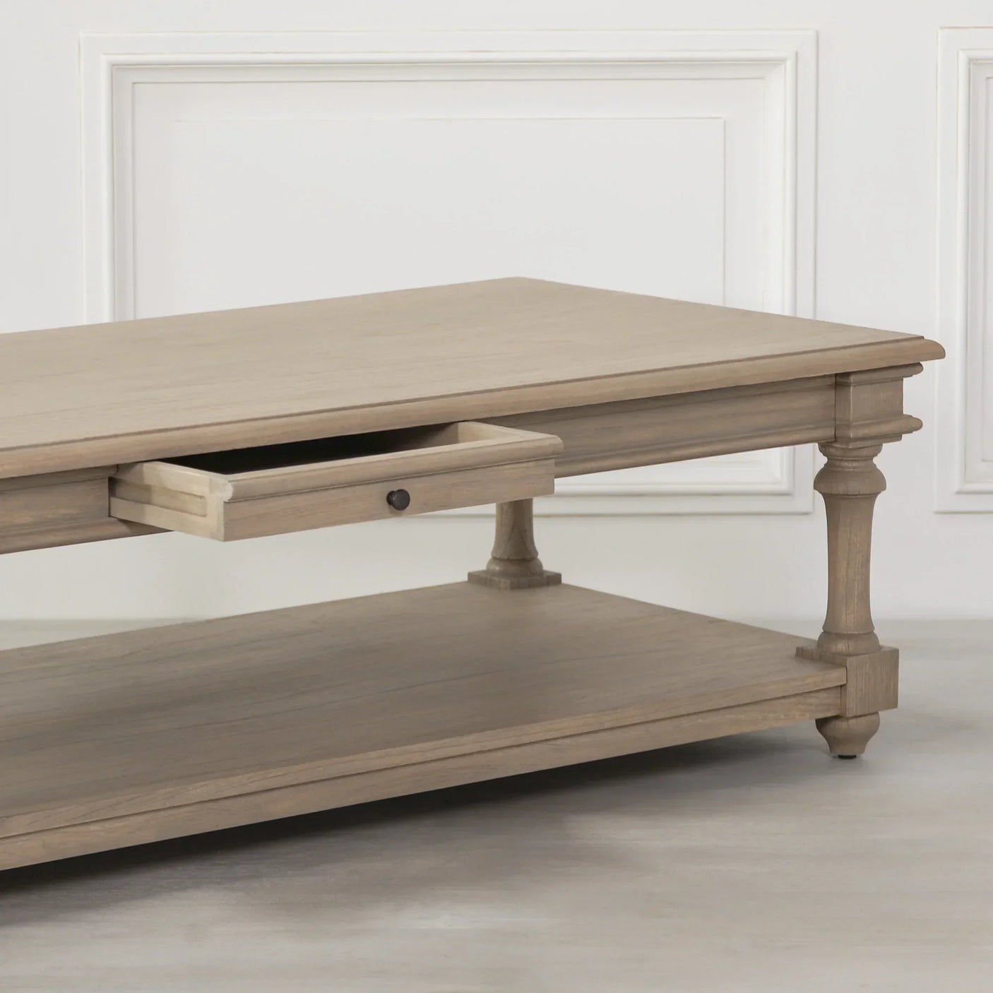 Oak coffee table with storage drawer and lower shelf, turned legs, side angle view