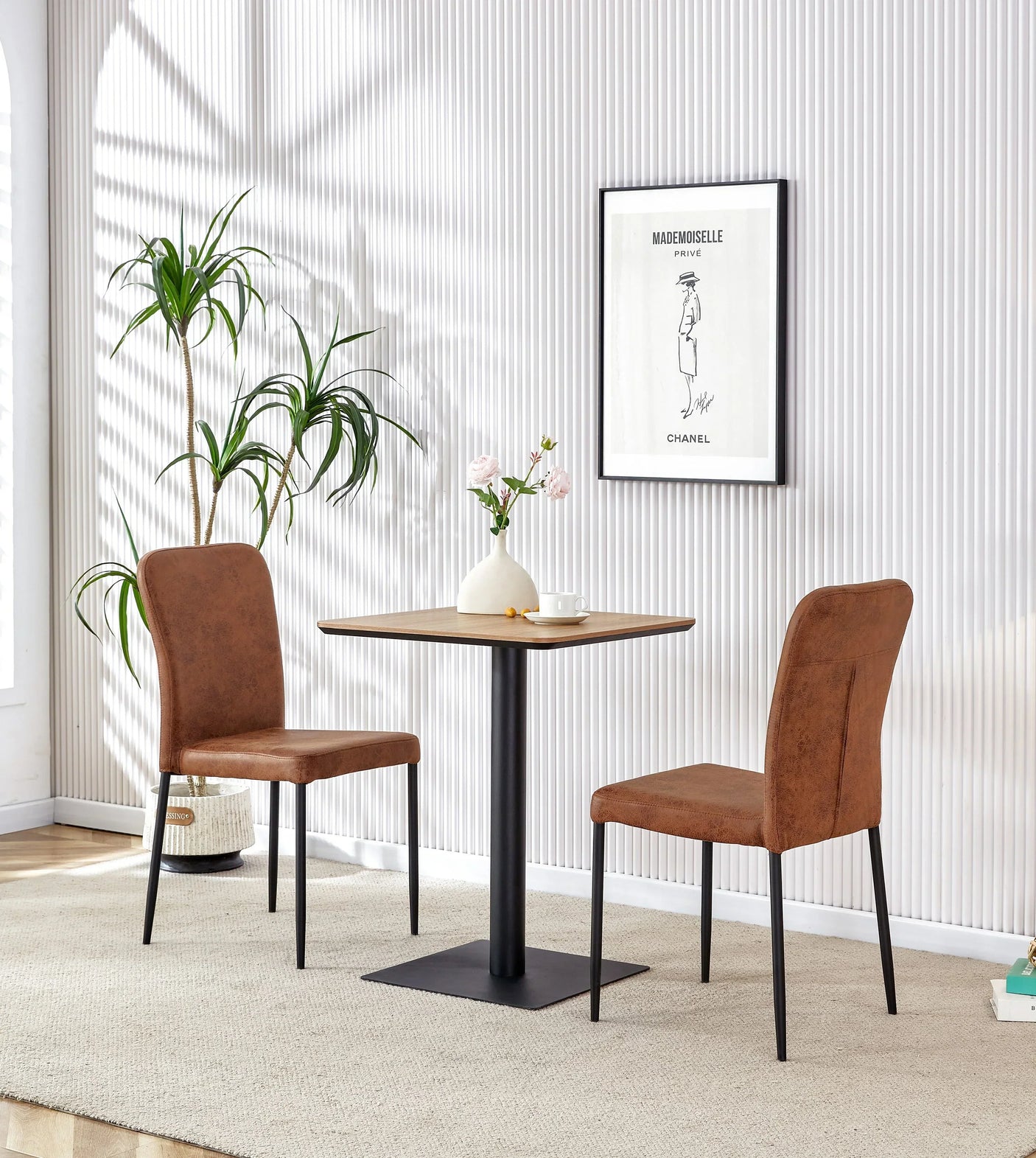 Square oak dining table with black base and two tan chairs in a modern room