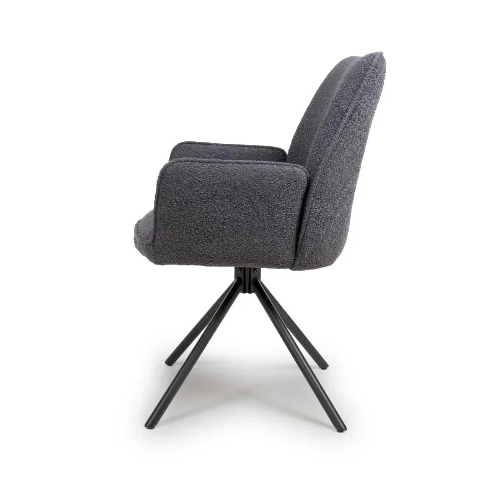 Grey fabric dining chair with padded seat and black angled metal legs side view