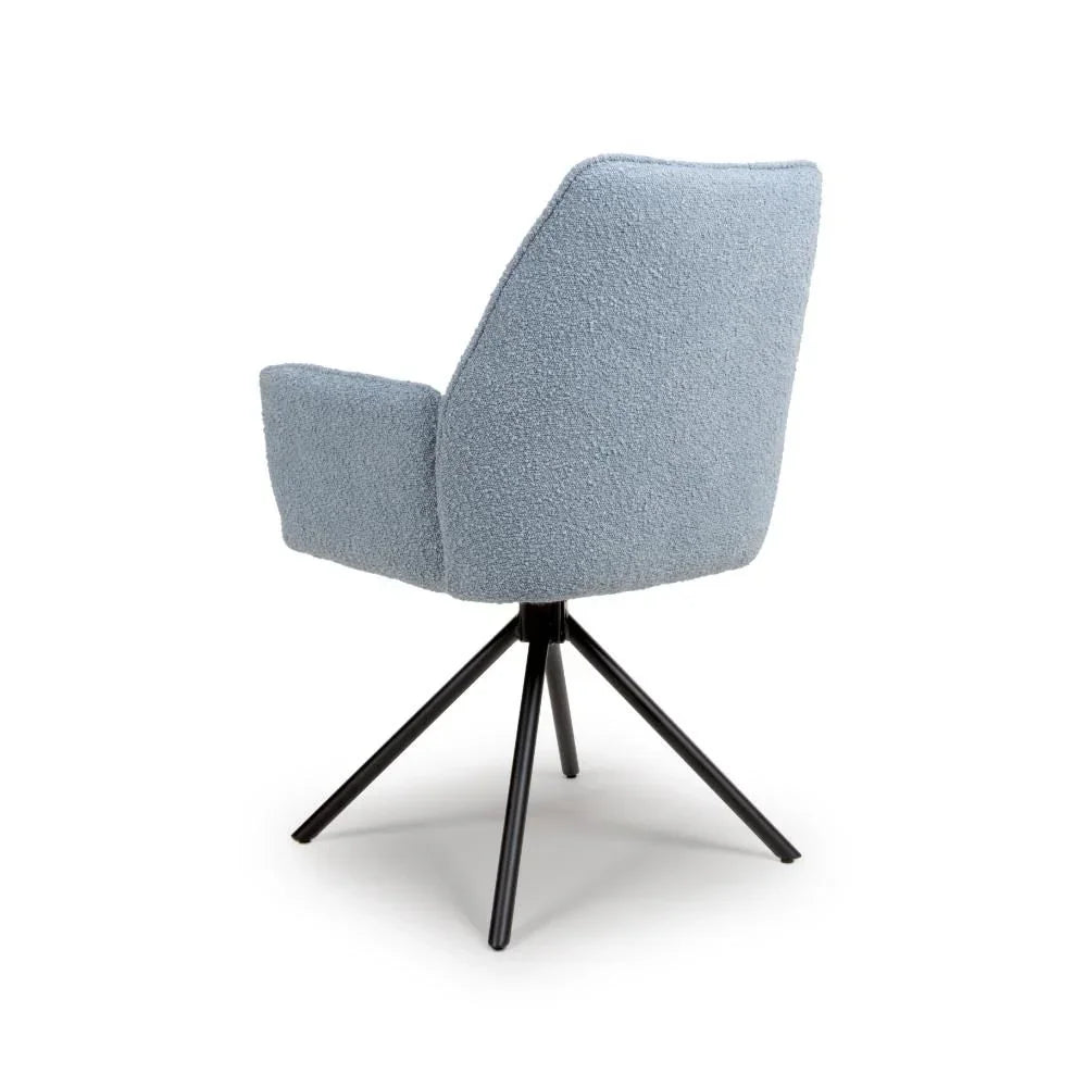Light blue fabric swivel dining chair with black metal legs, rear angled view