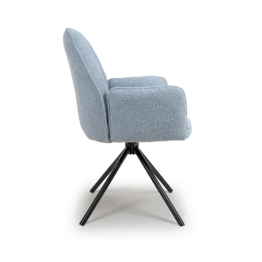 Light blue boucle swivel dining chair with black metal legs, side profile view