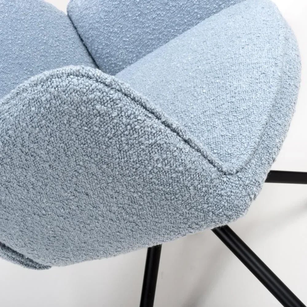 Close view of blue boucle fabric dining chair with black metal legs