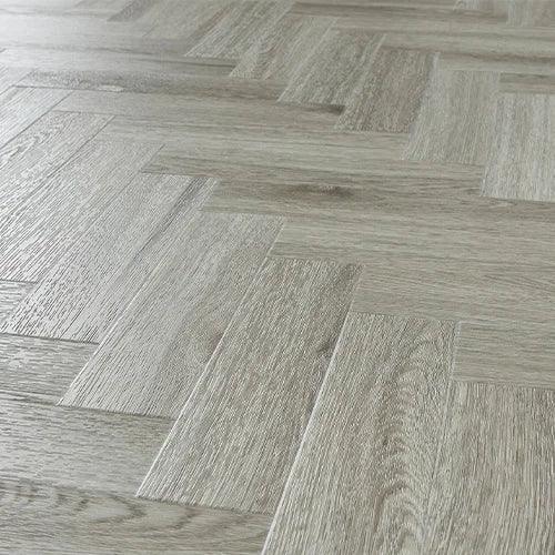 Urban grey wood effect flooring in herringbone pattern, close-up of textured planks