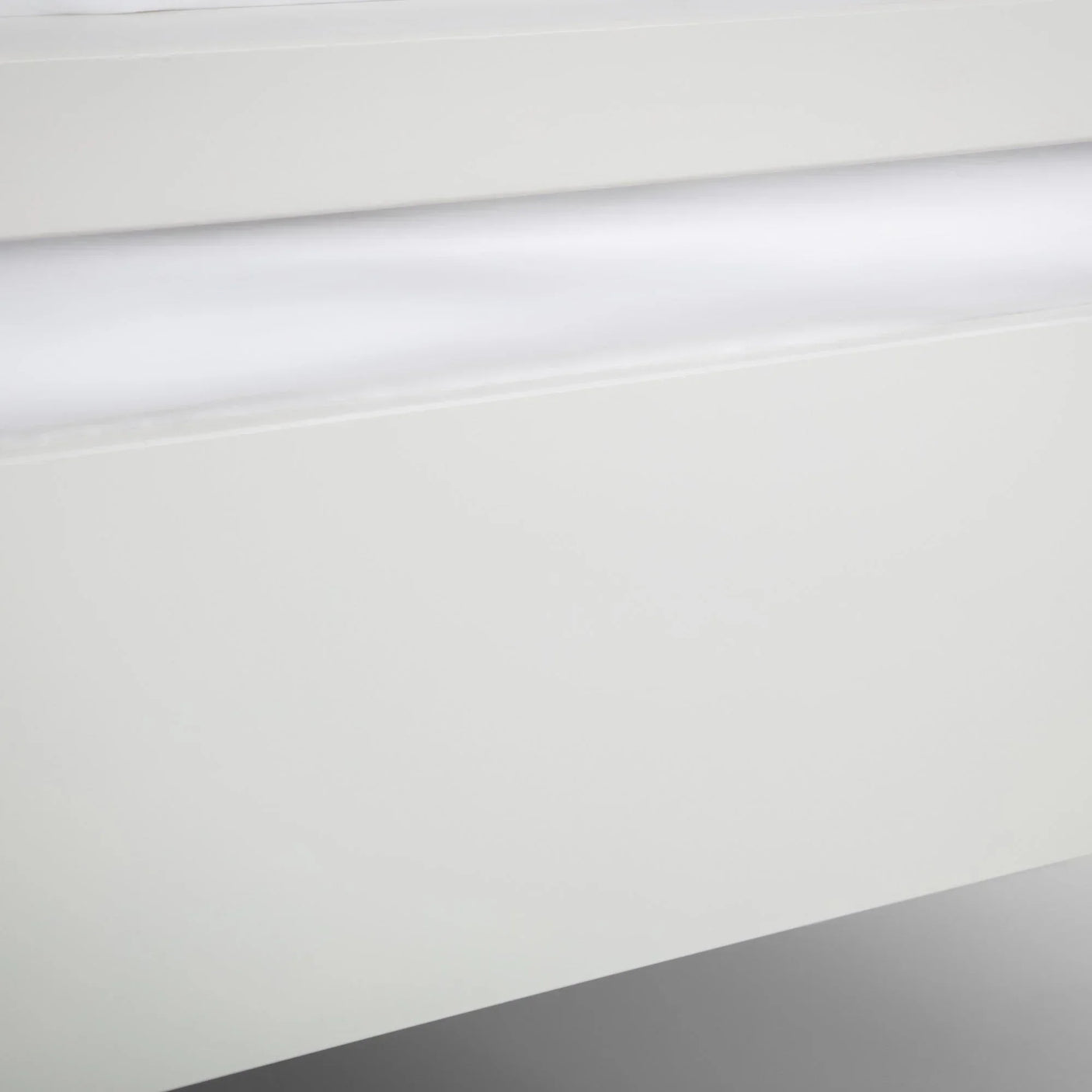 Close-up of white bed frame corner with smooth painted finish