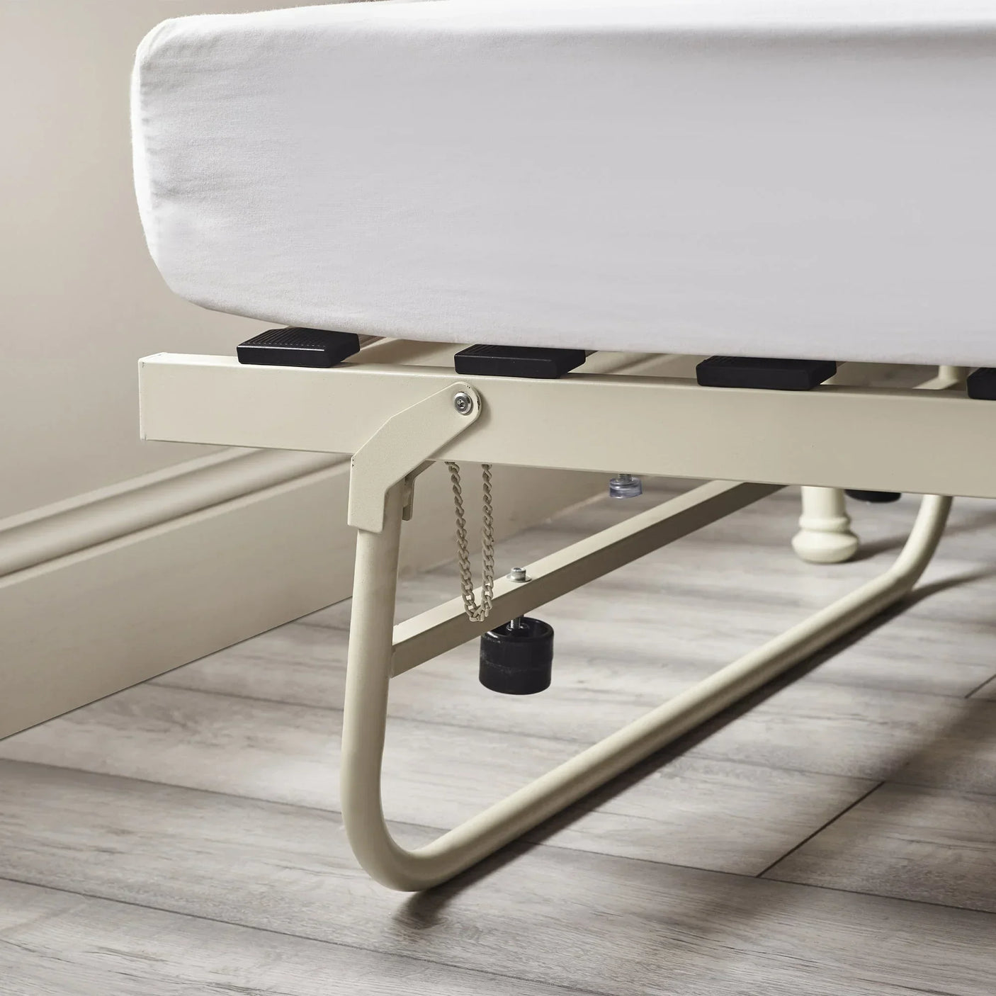 Stone white metal daybed frame detail with slats and leg support on wooden flooring
