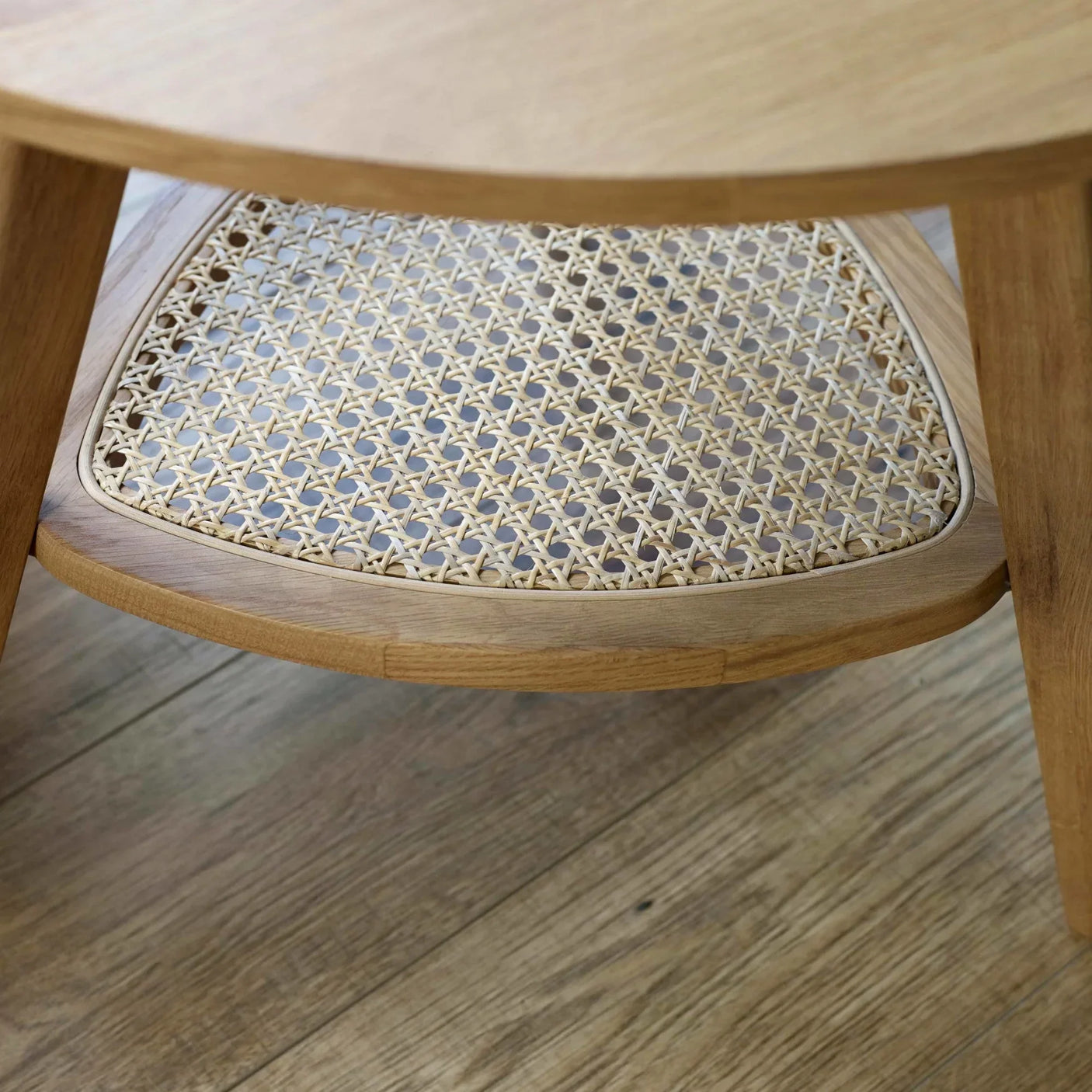 Wooden coffee table with rattan shelf detail on oak floor