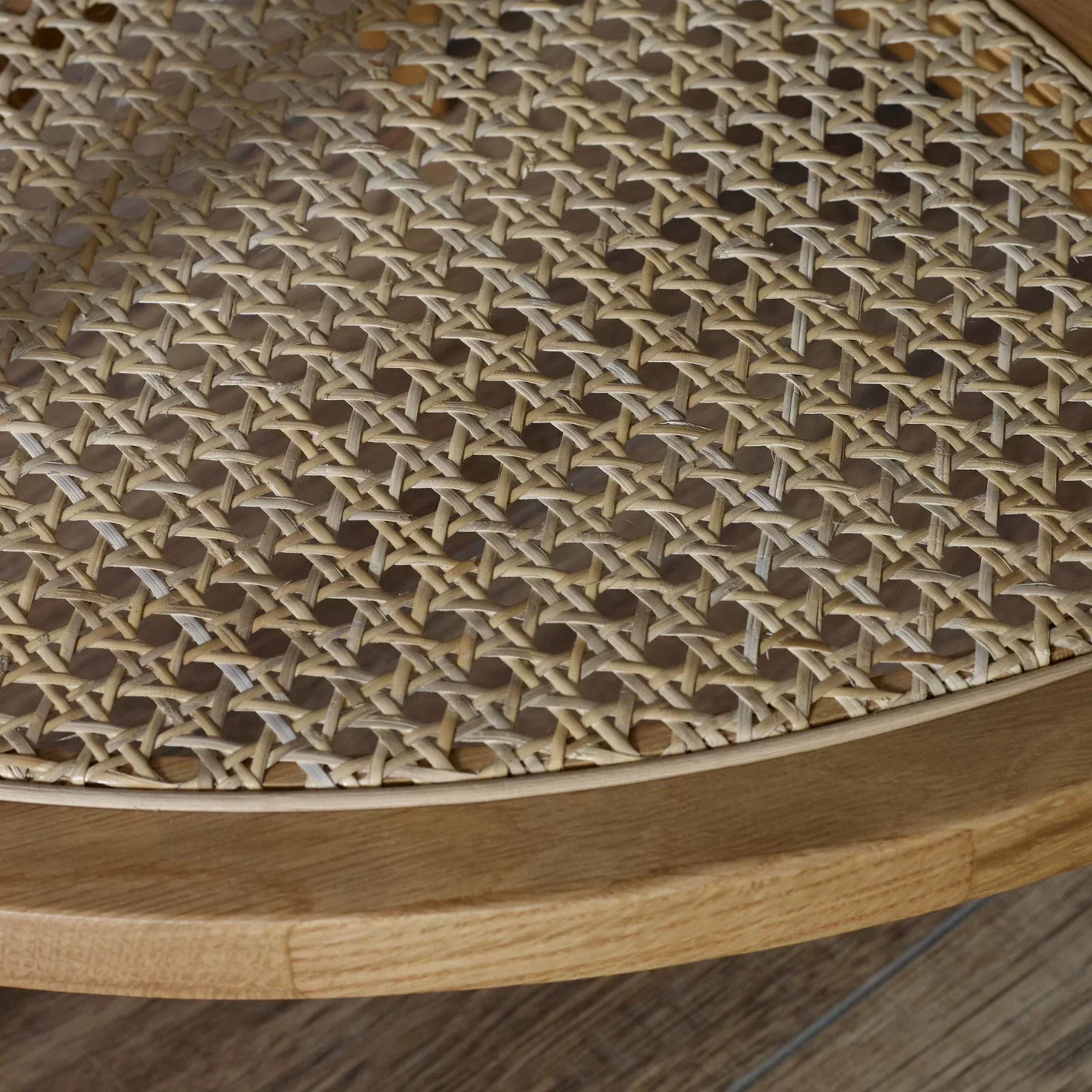Round rattan coffee table closeup showing woven cane top and light wood frame