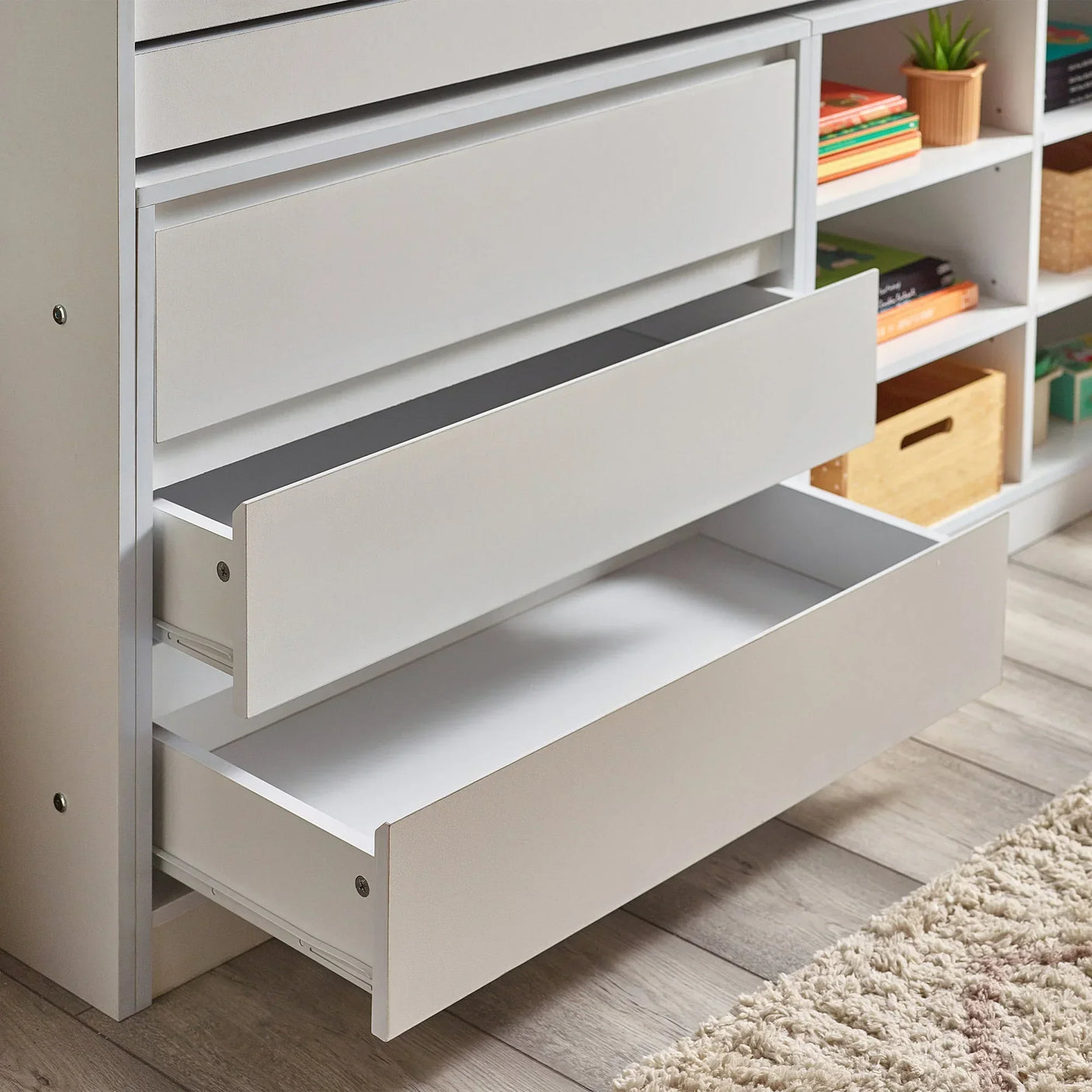 Vespa midsleeper bed storage drawers open next to shelves with books and baskets