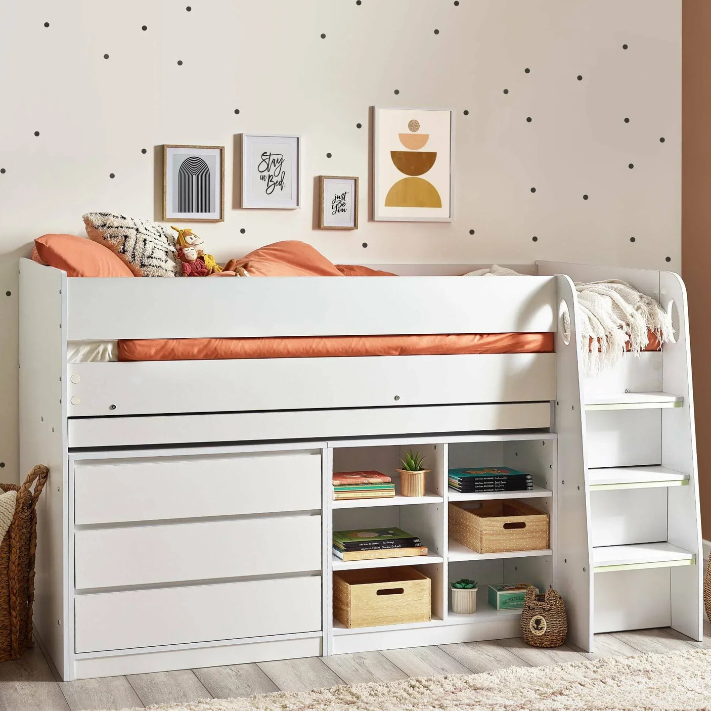 White midsleeper bed with stairs, storage drawers, shelves, and orange bedding in kids room